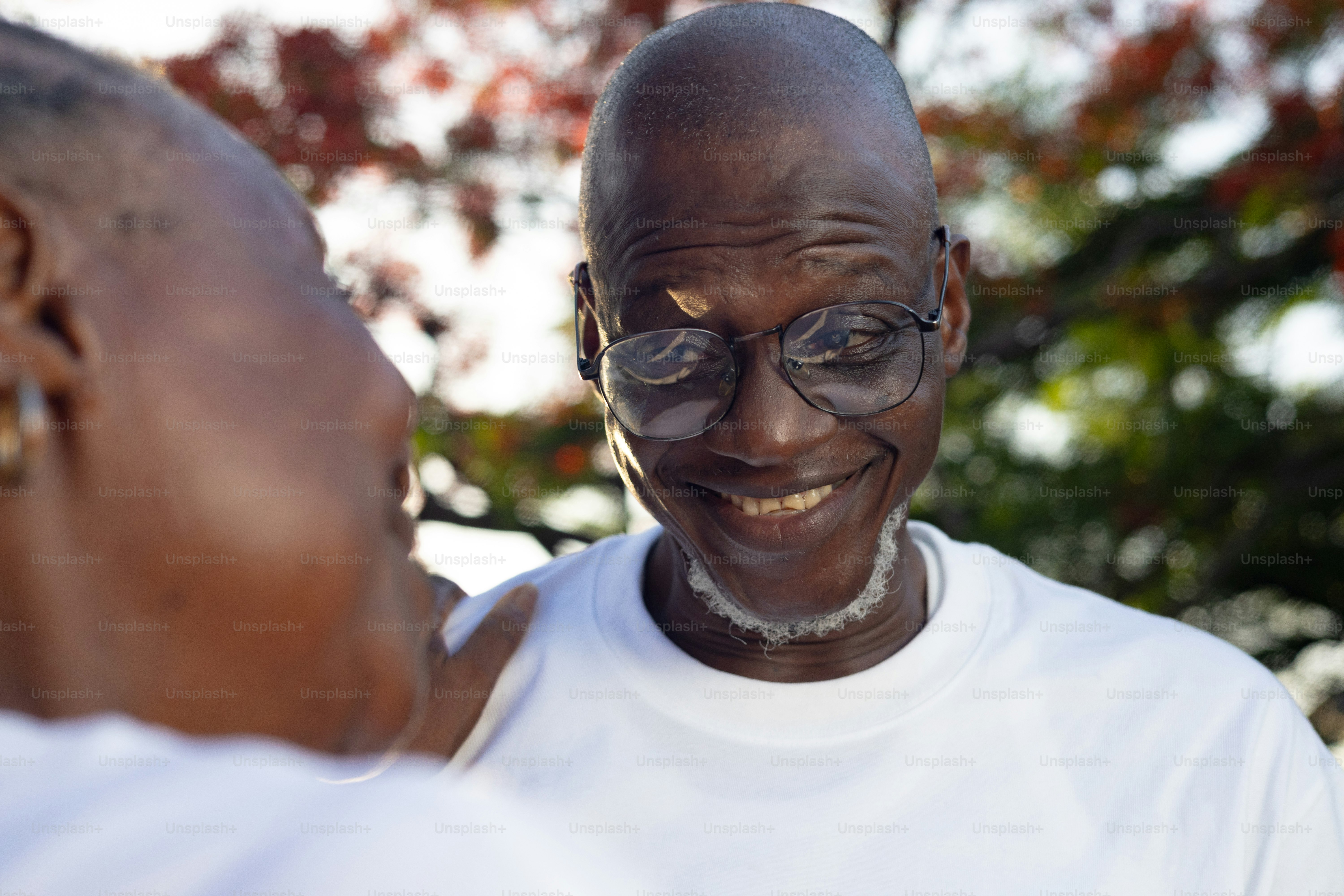 Un homme souriant regarde une autre personne avec amour.
