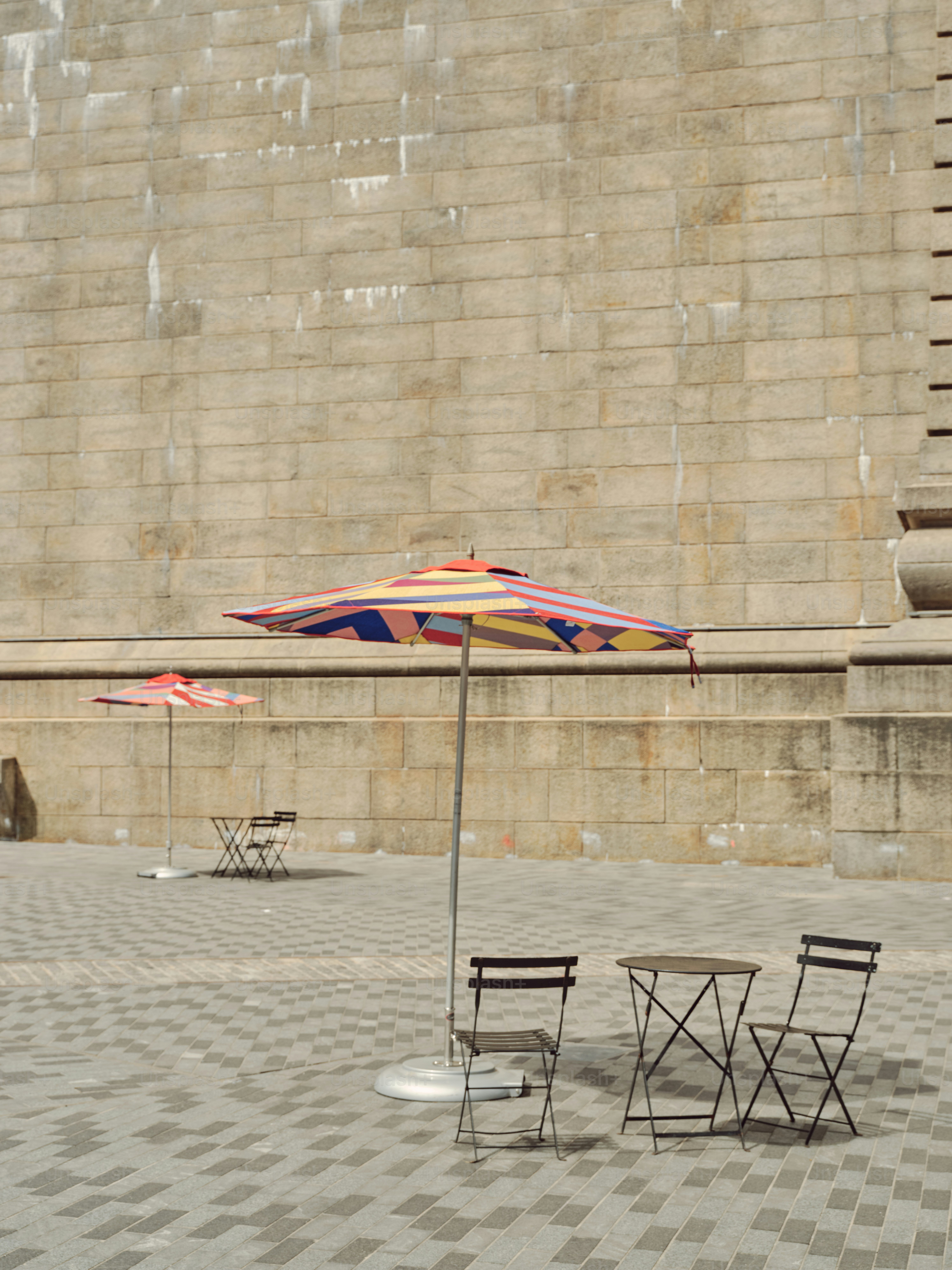 Empty cafe tables and umbrellas stand outside.