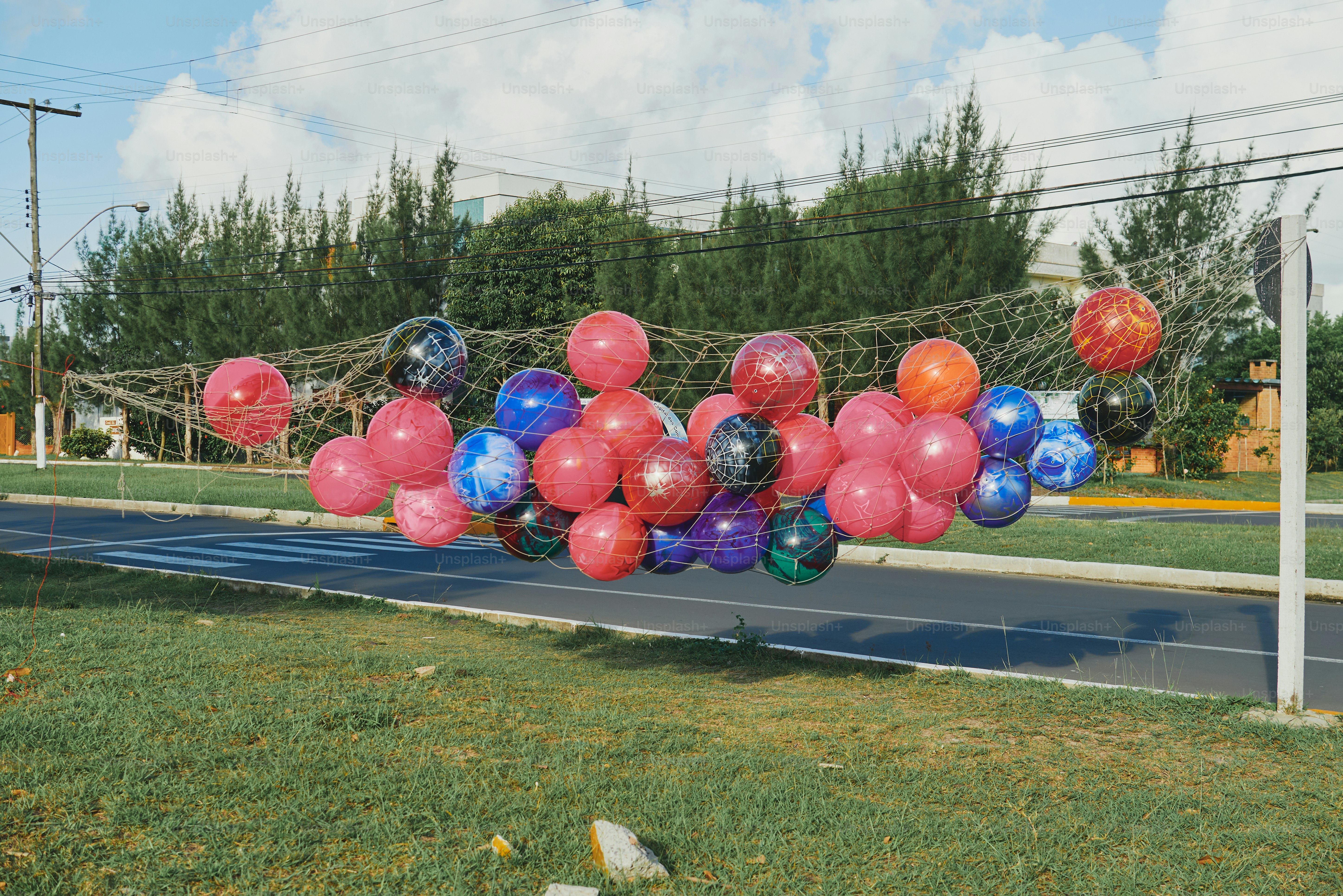 Luftballons sind in einem Netz über der Straße gefangen.