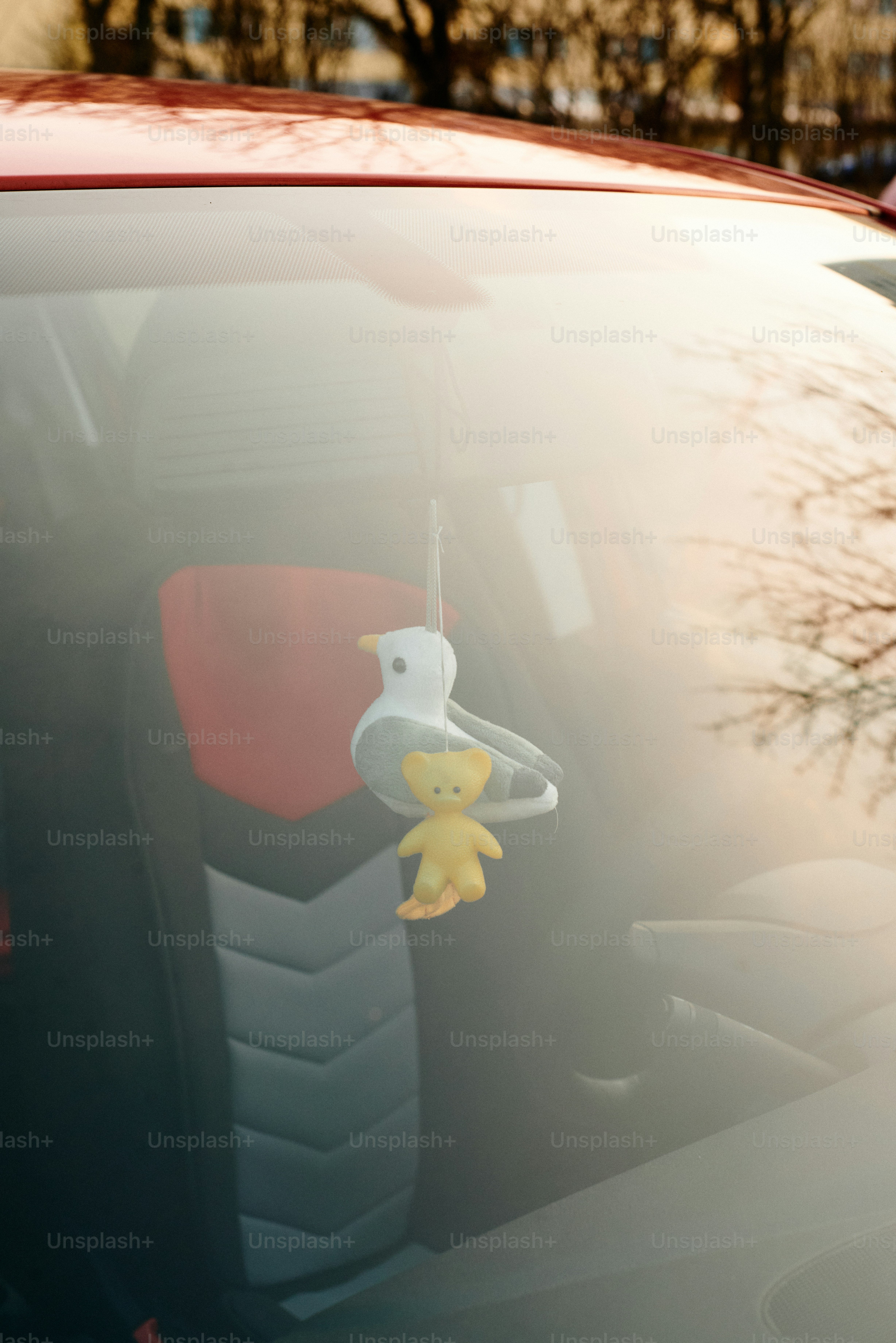 A car ornament hangs from the rearview mirror.