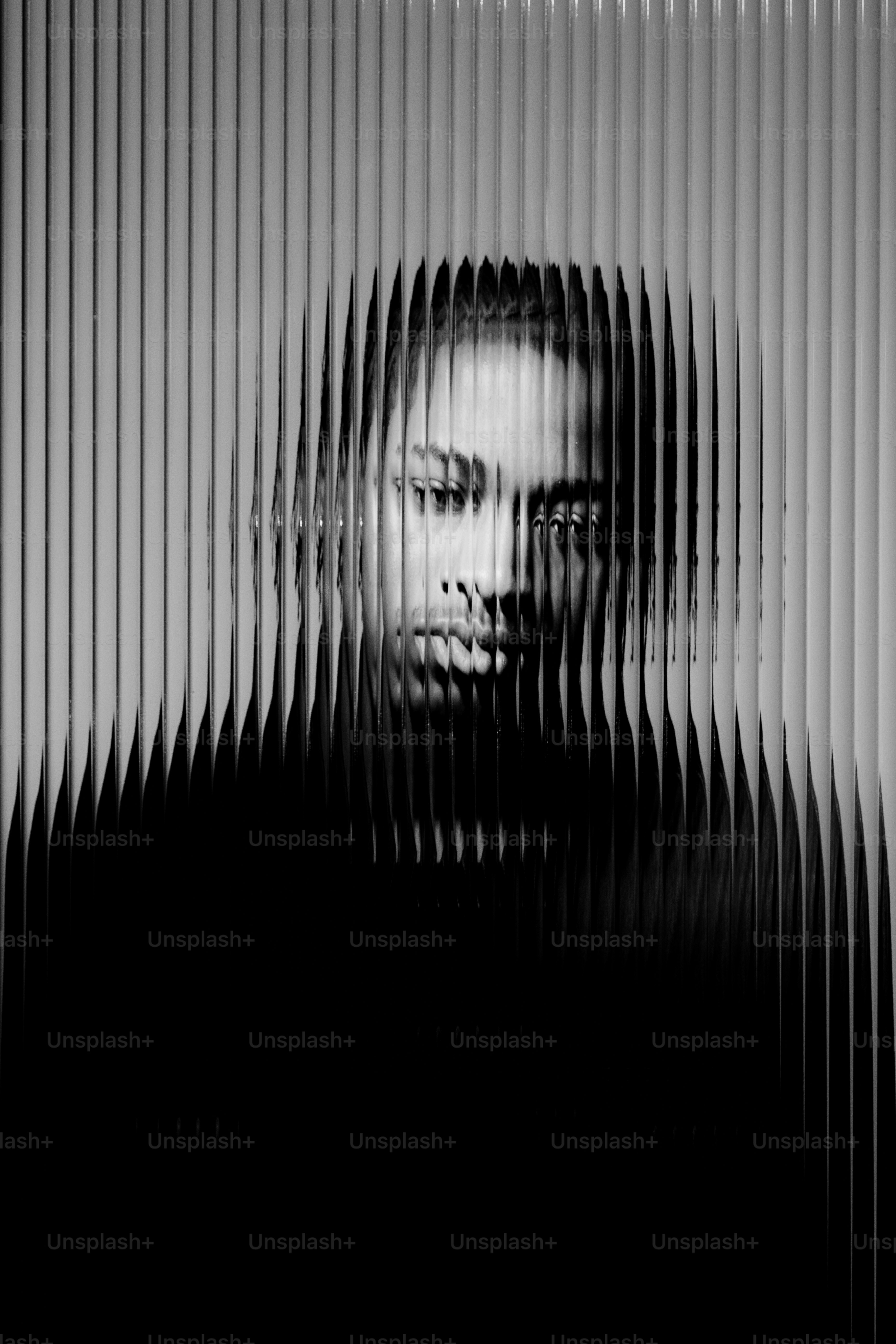 Wajah seseorang terlihat melalui permukaan bertekstur.