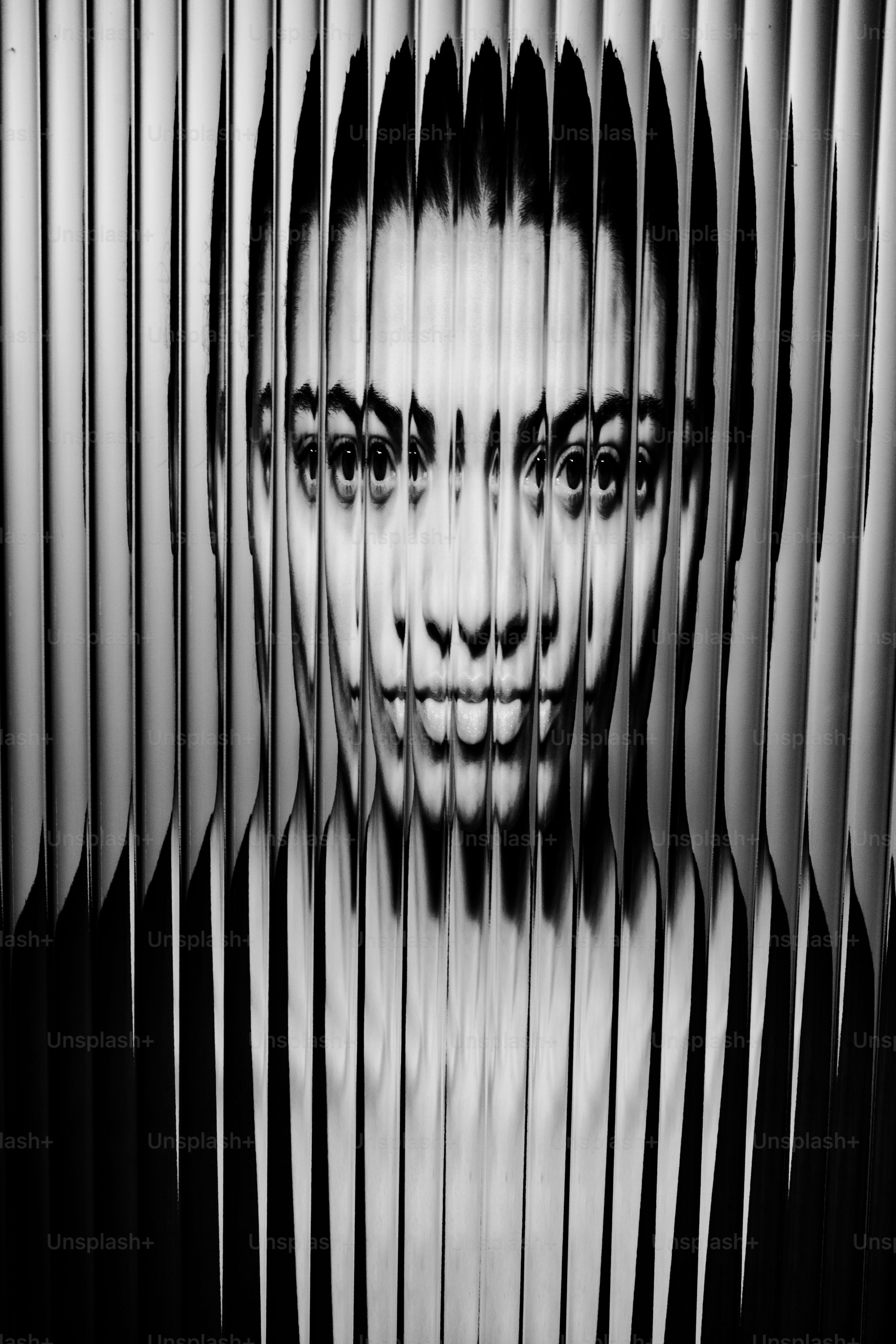 A woman's face refracted through vertical lines.