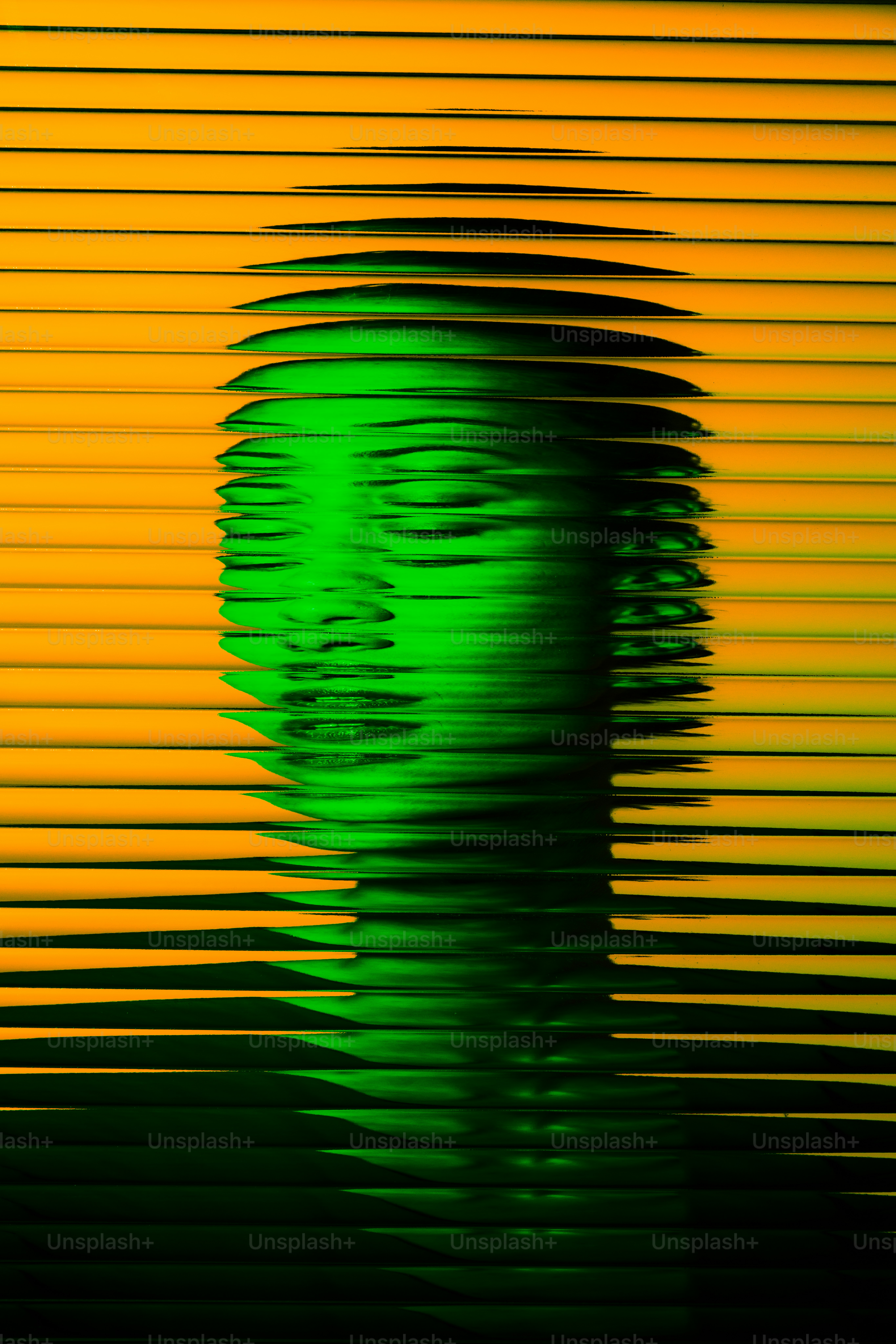 Green-tinted face behind yellow, horizontal blinds.