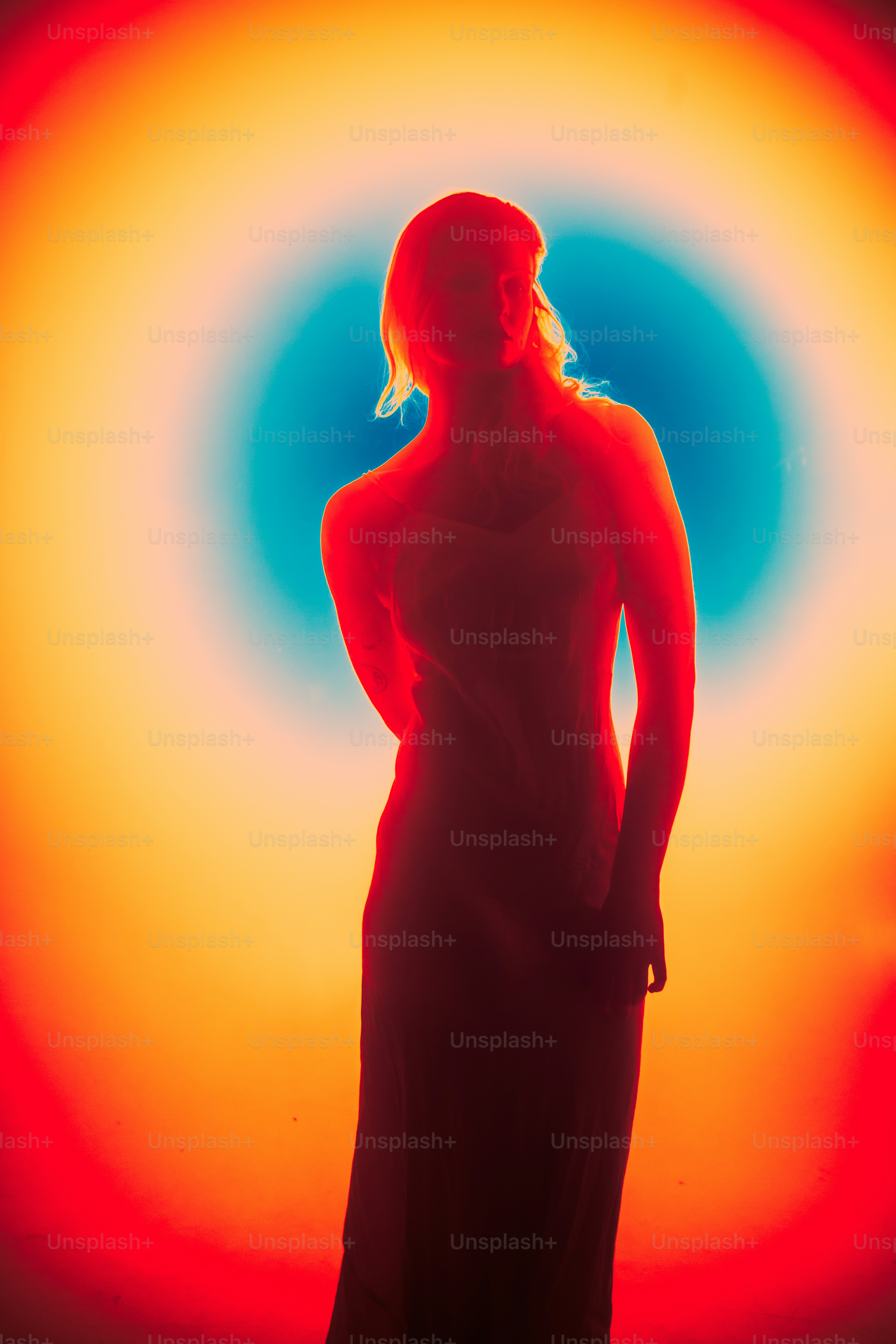 Silhouette of a woman against colorful, glowing background.