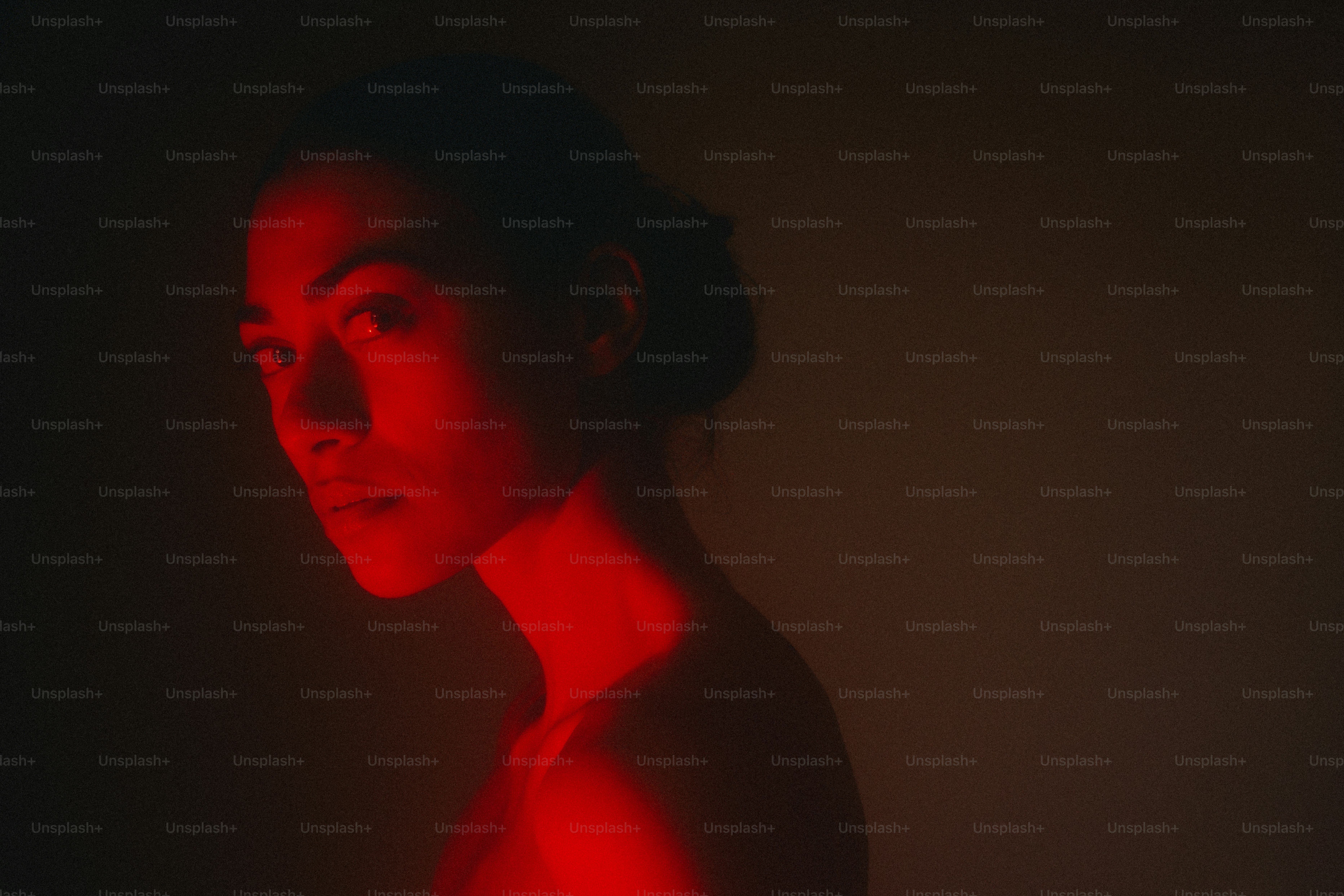 A woman is lit by red light.