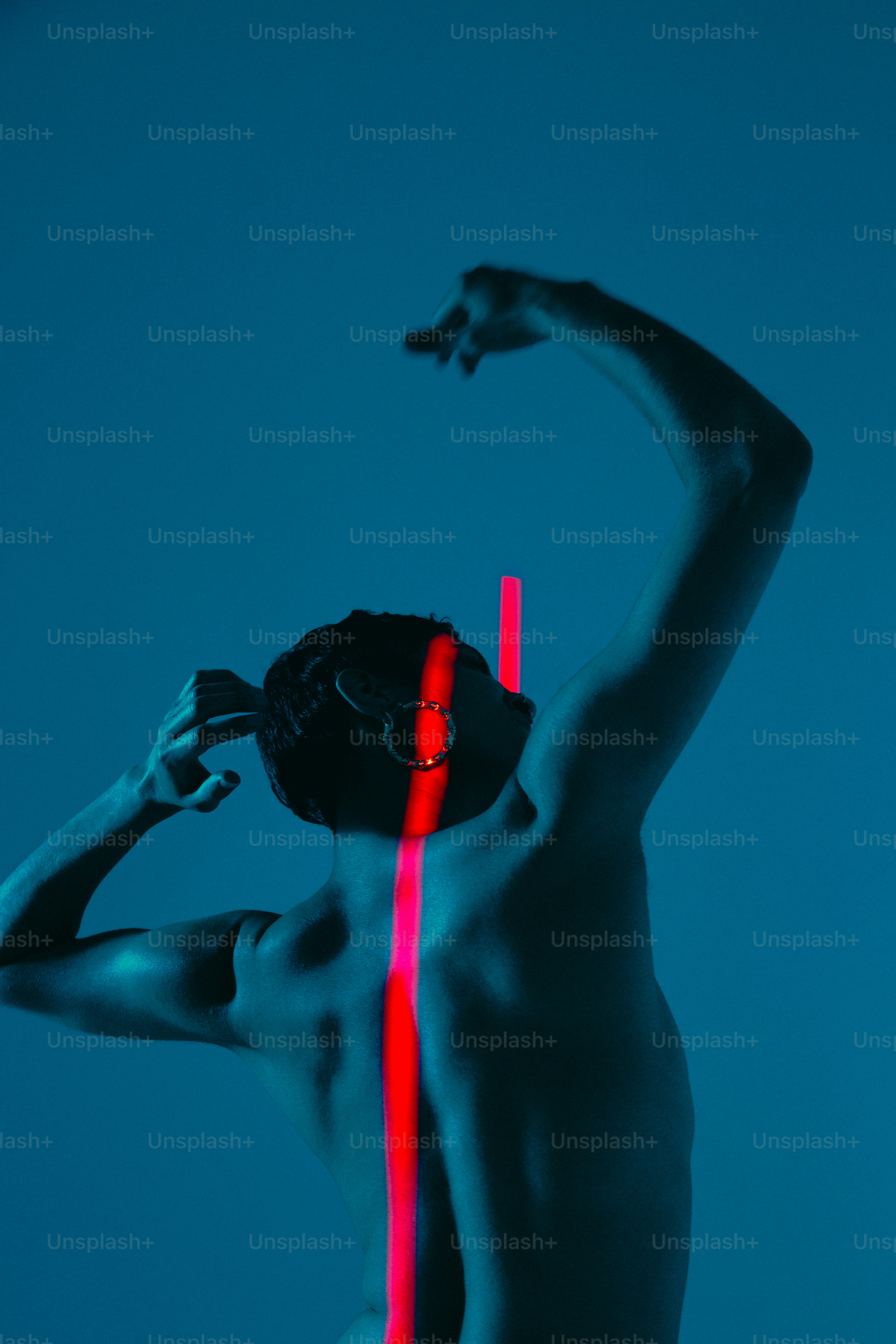 Una persona posa con una vibrante luce rossa.