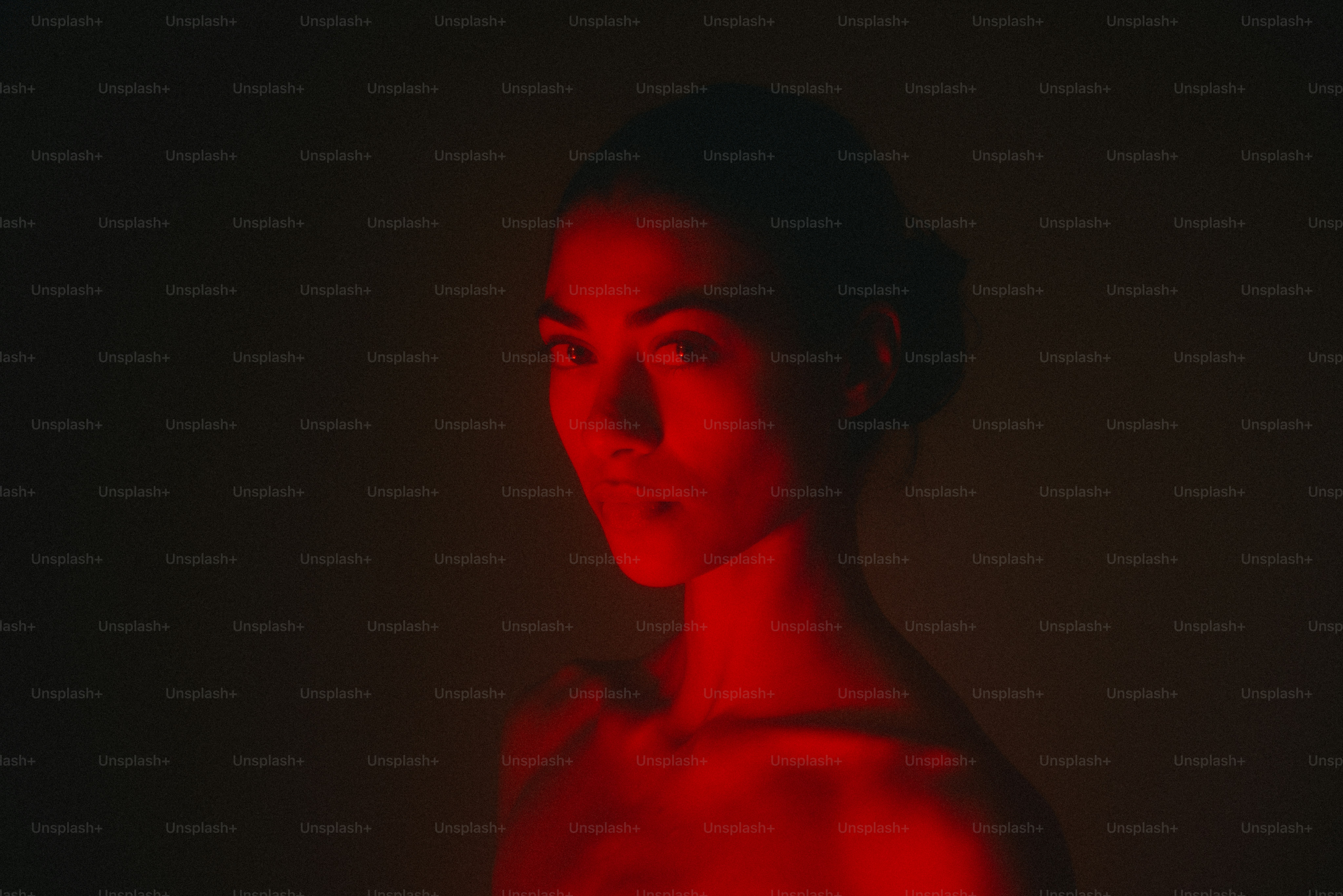 Woman's face is bathed in red light.