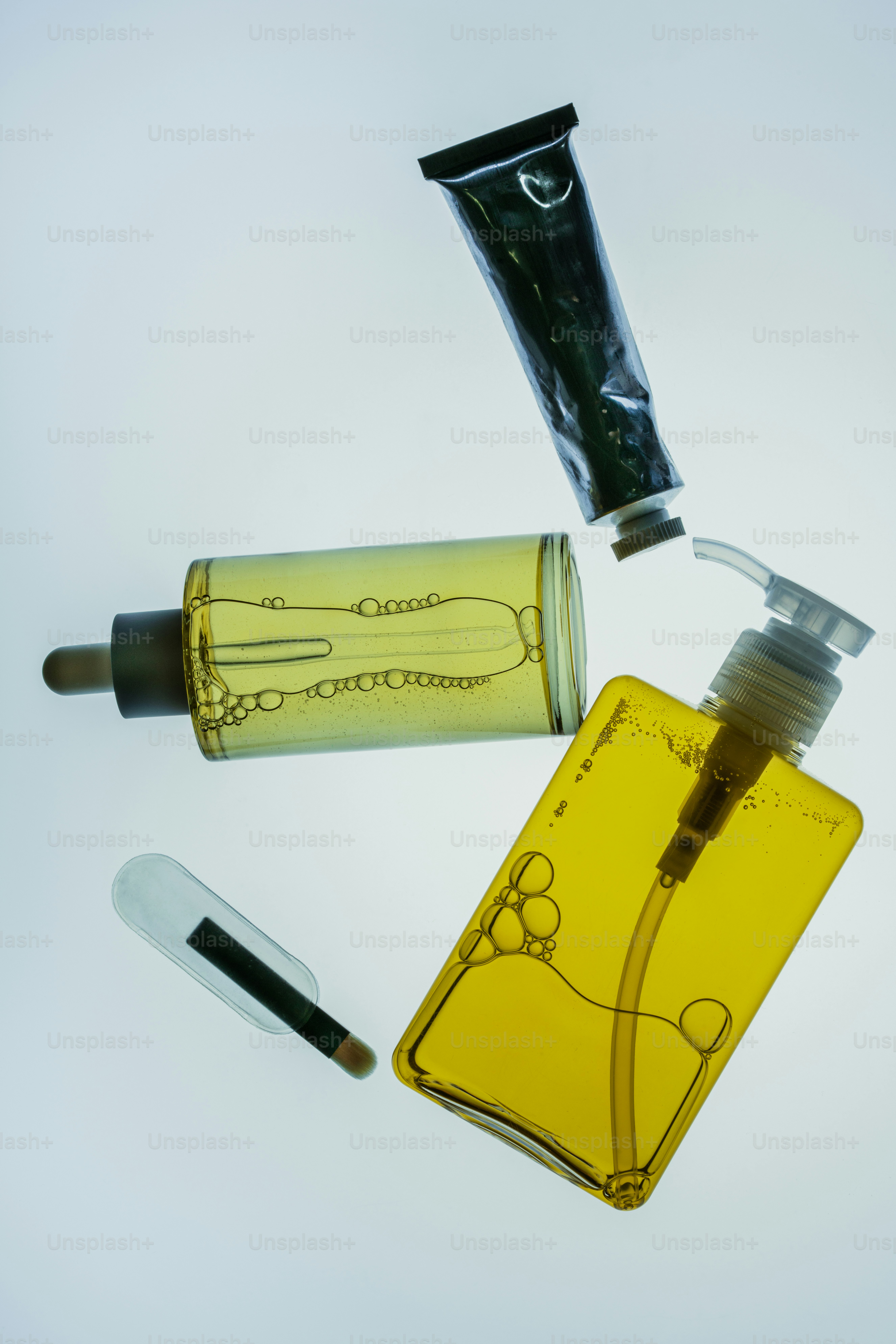 Les produits cosmétiques et les accessoires sont disposés sur une surface blanche.