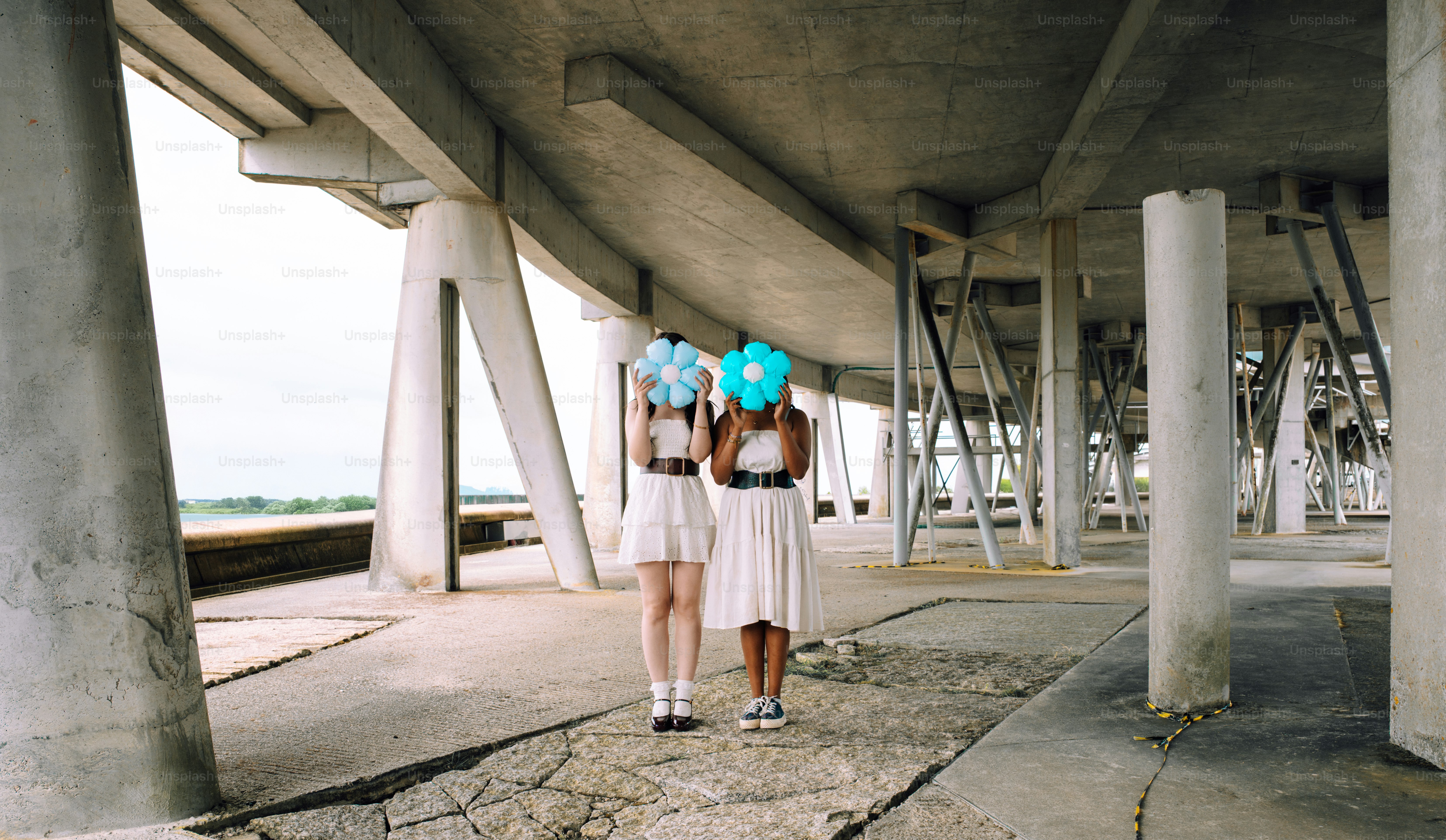 コンクリート構造物の下に光る球体を持つ2人の女性。