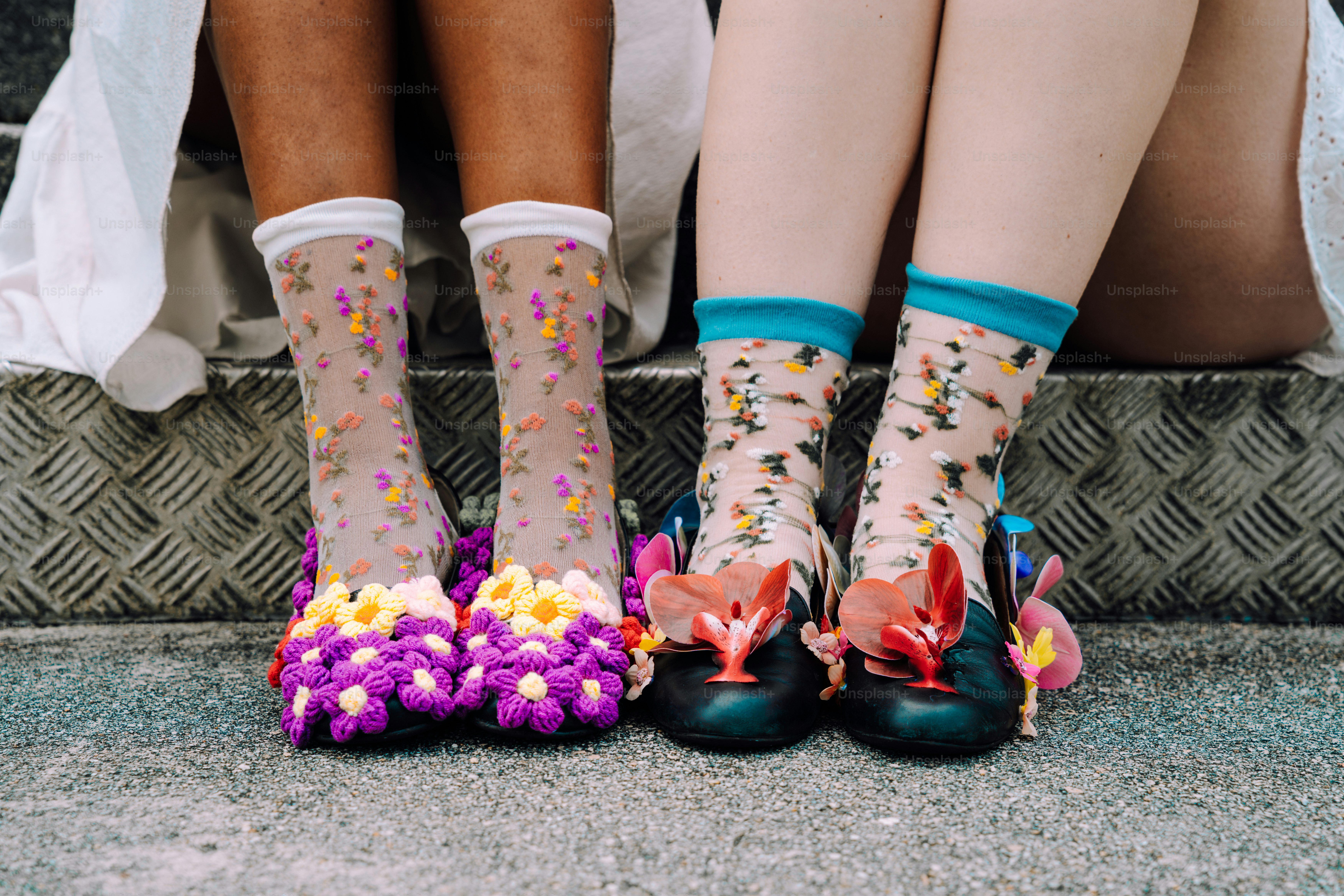 Zwei Personen zeigen ihre bunten, gemusterten Socken und Schuhe.