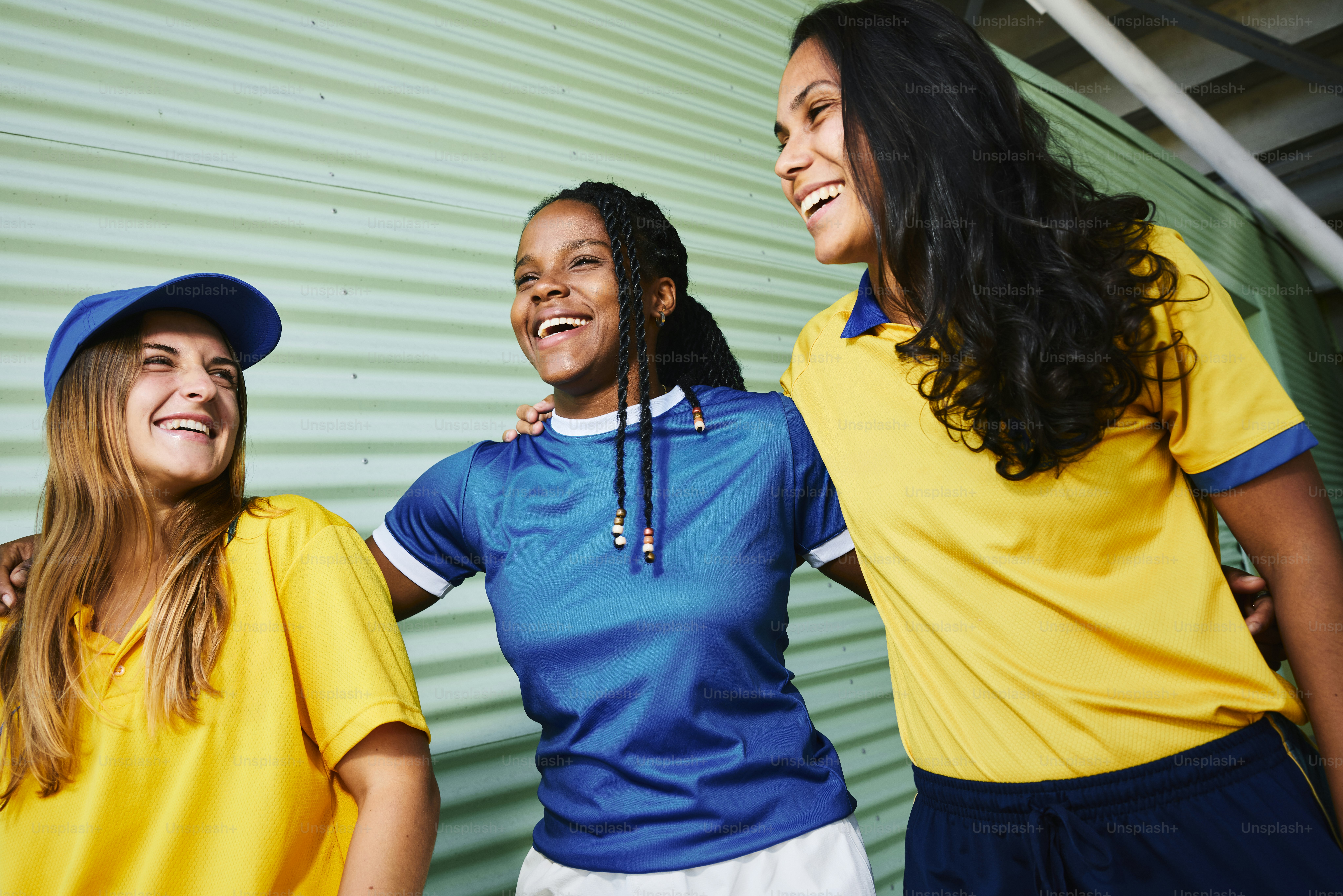 Three young women smile and laugh together.