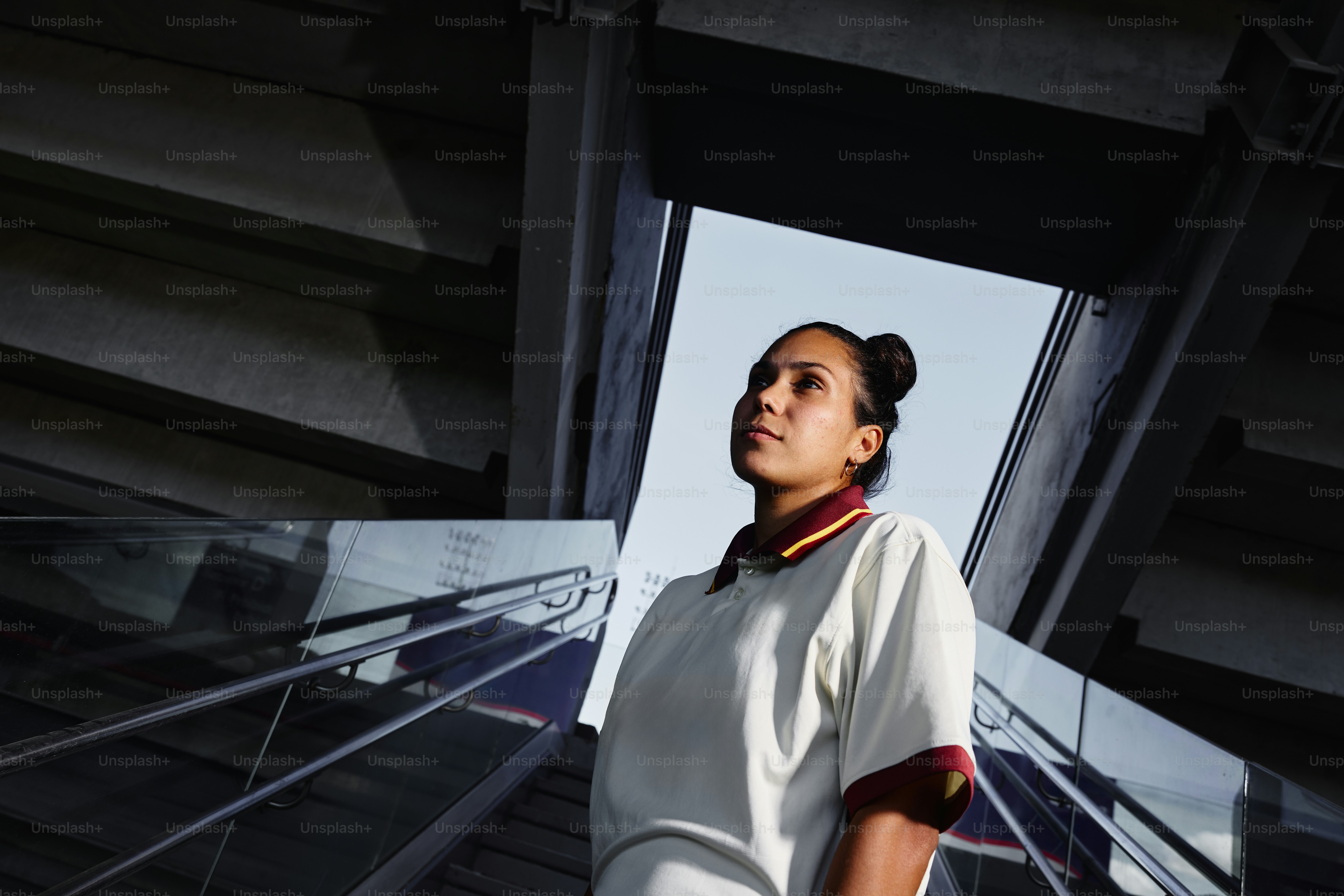 A woman looks up from a stadium structure.