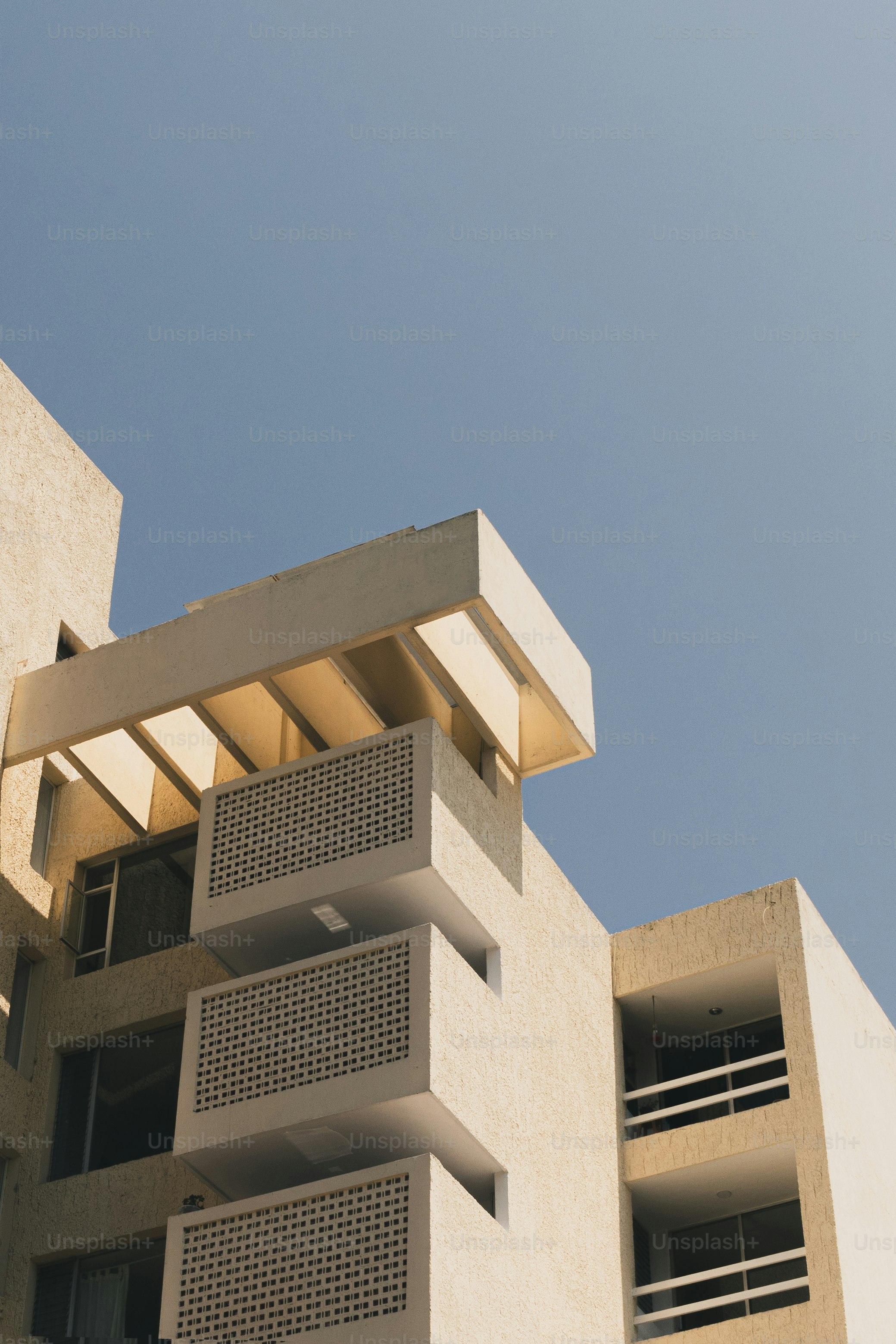 A modern building is reaching towards the blue sky.