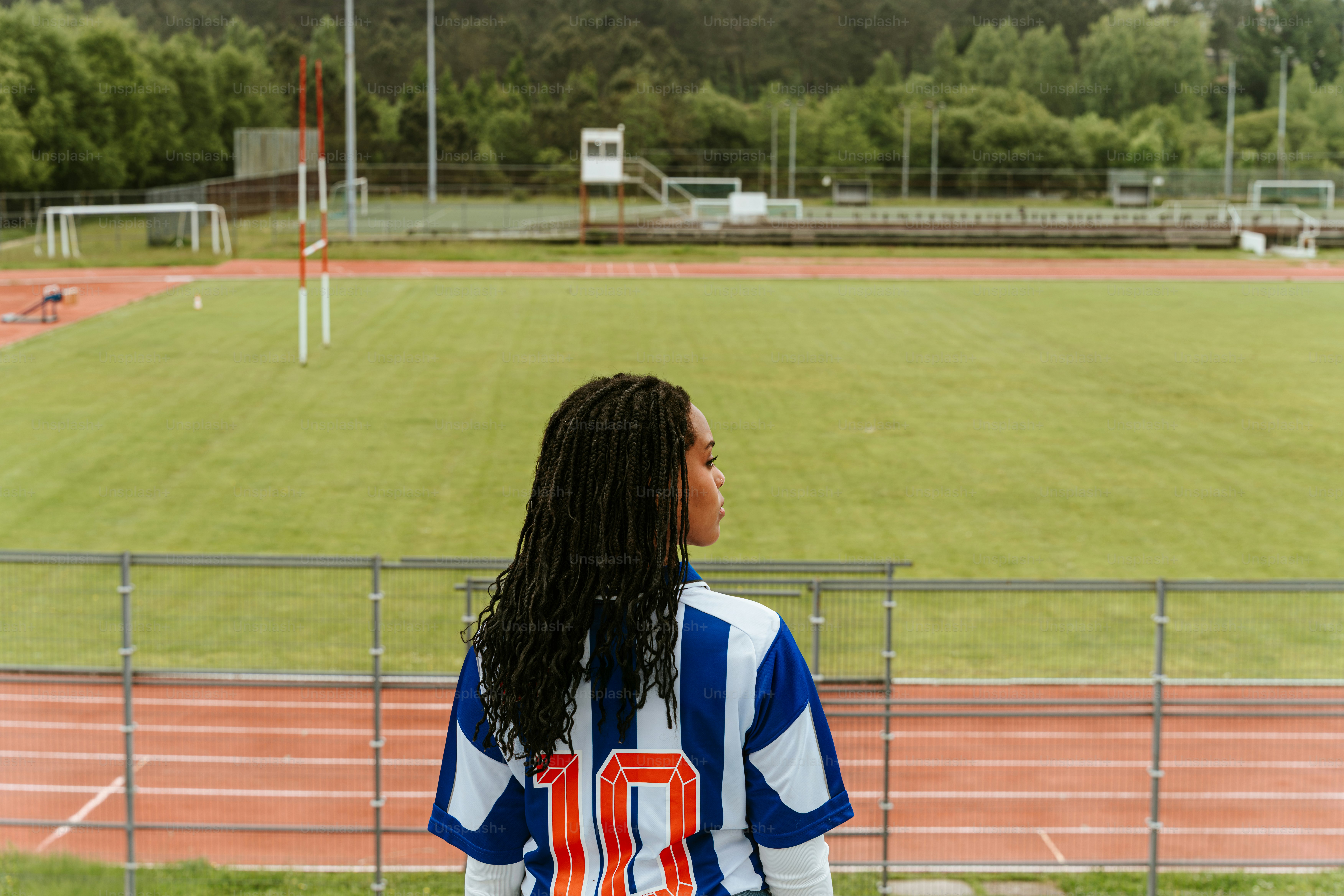 A soccer player stands and views the field.