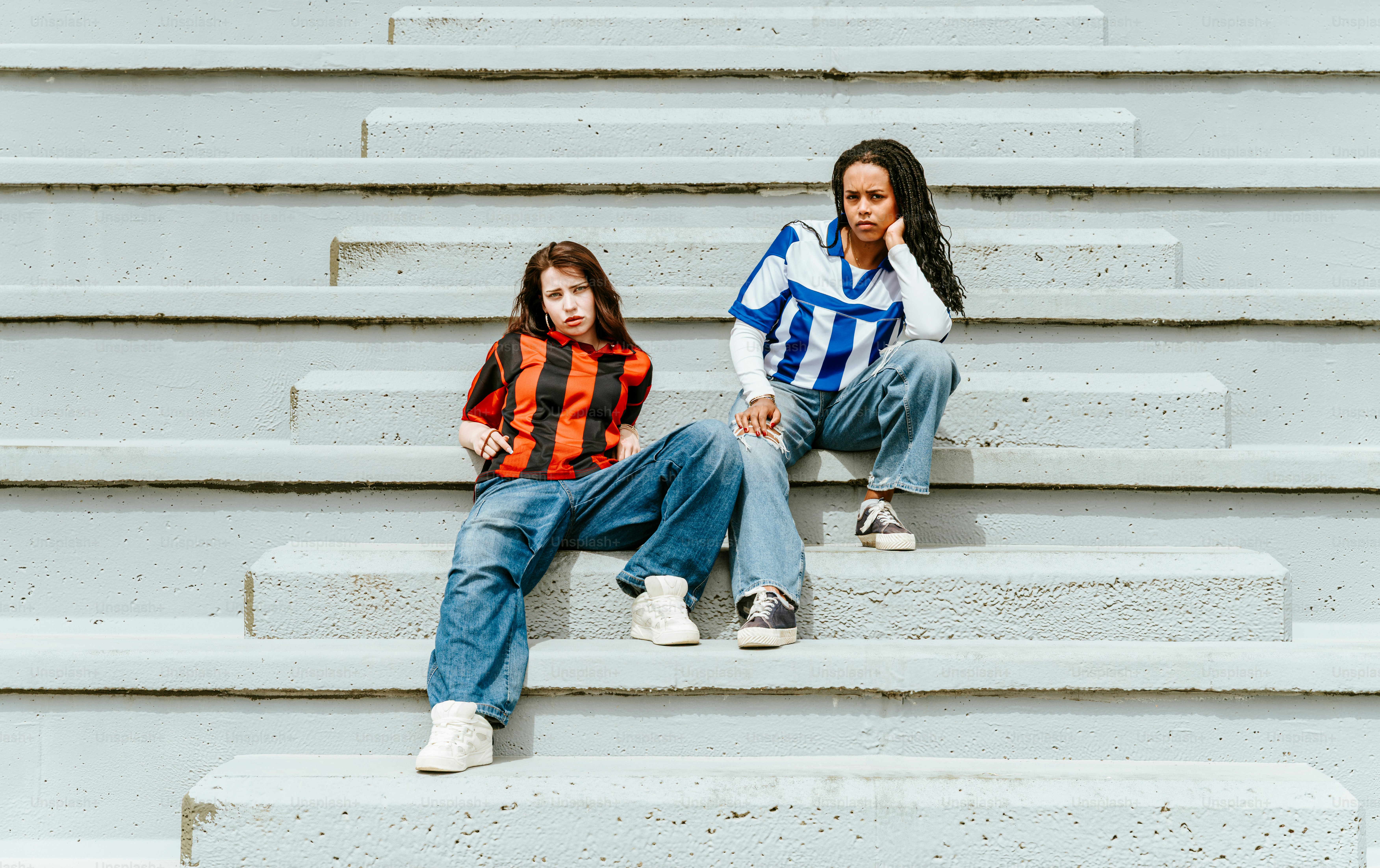 Two young women are sitting on some steps.