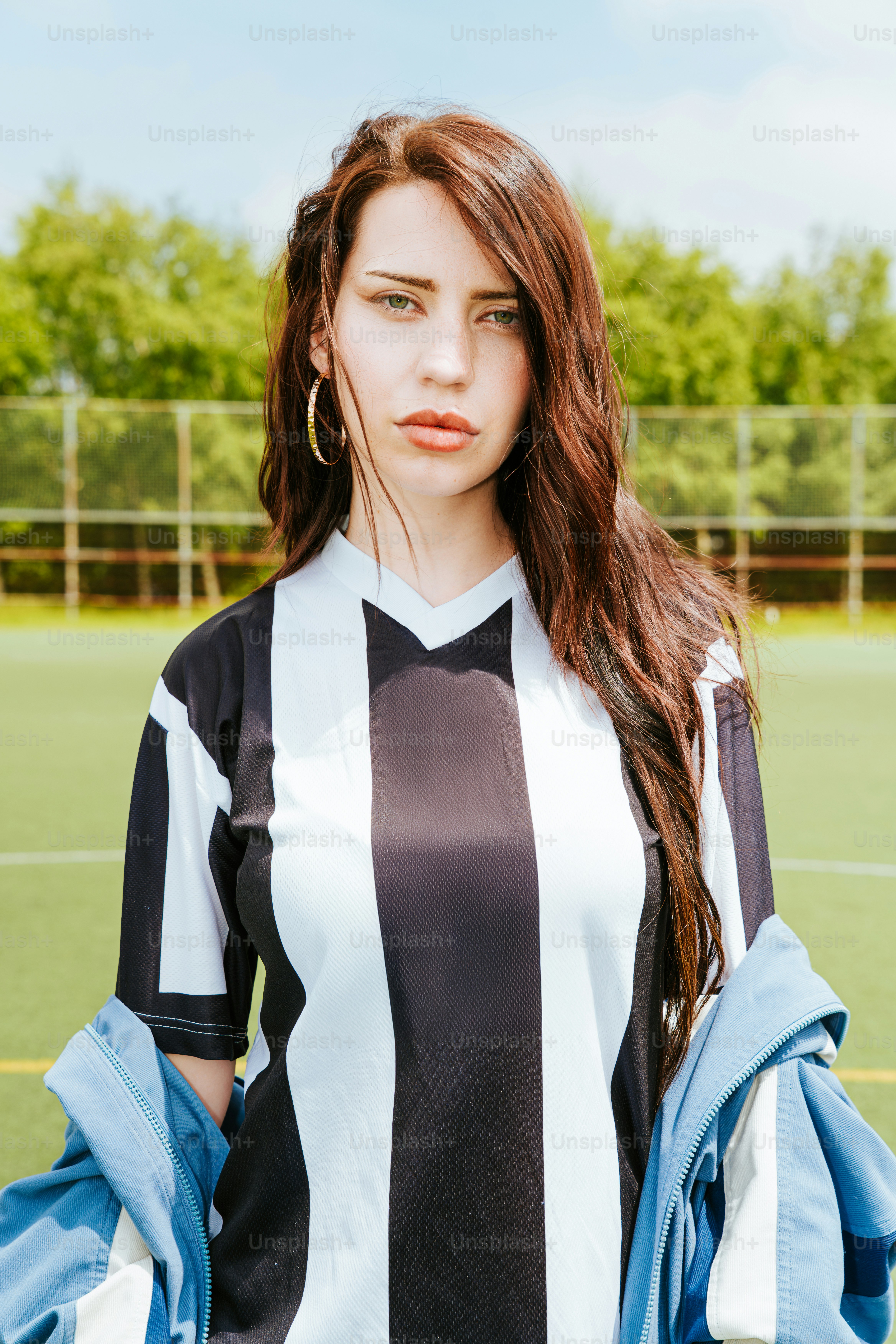 A woman poses in a soccer jersey.