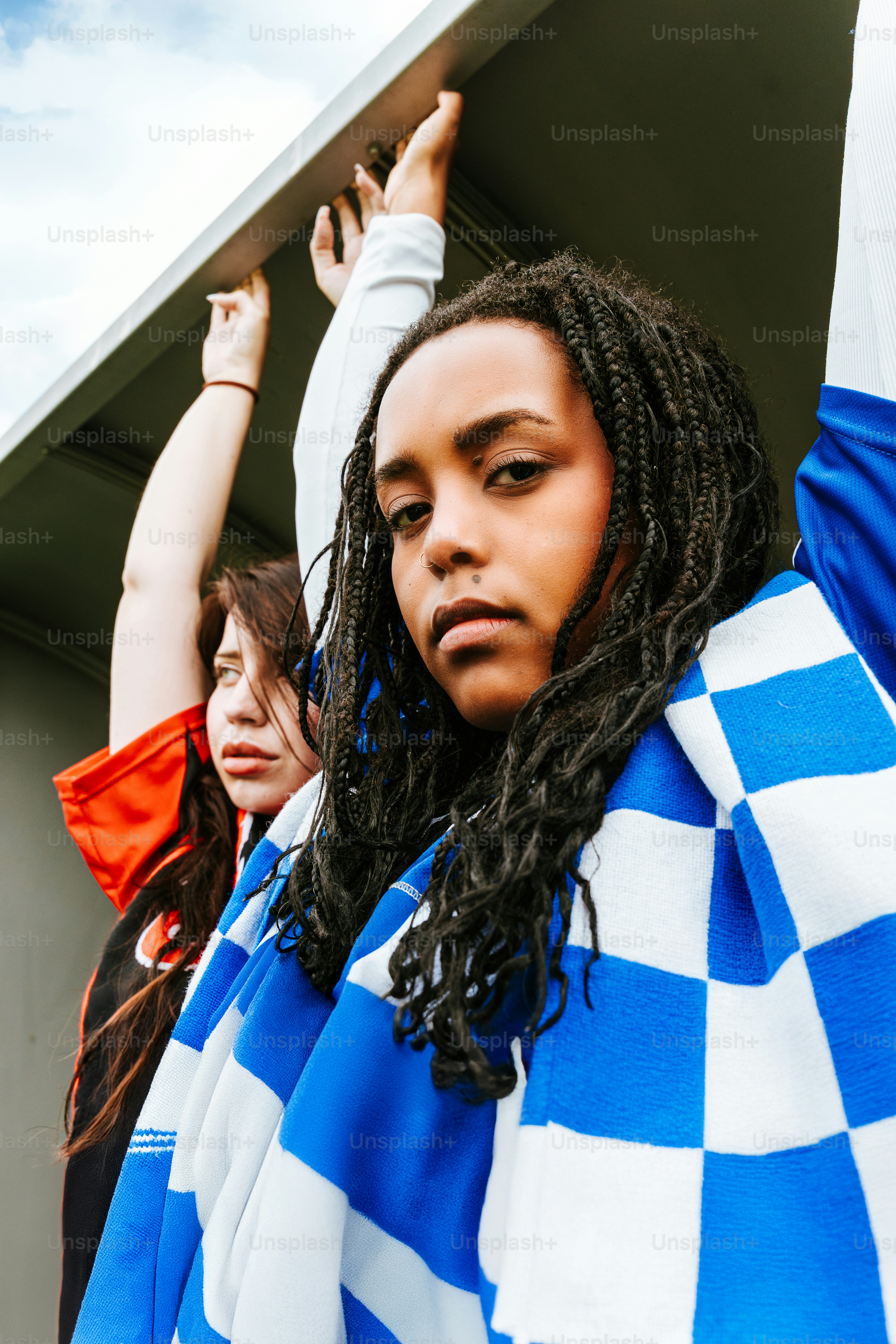 Deux personnes se tiennent ensemble avec des foulards bleus et blancs.