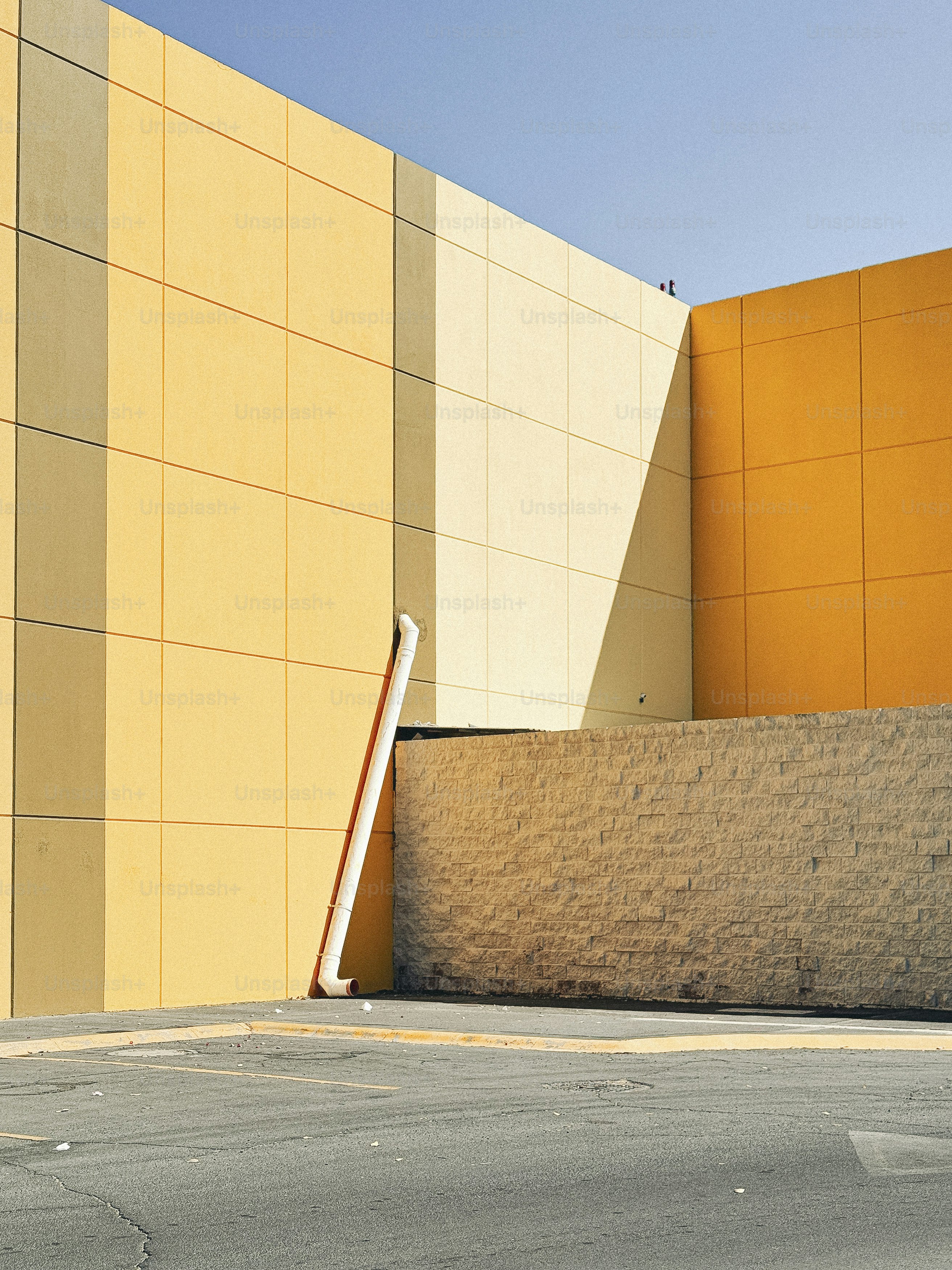 Vibrant yellow walls contrast the pavement and sky.