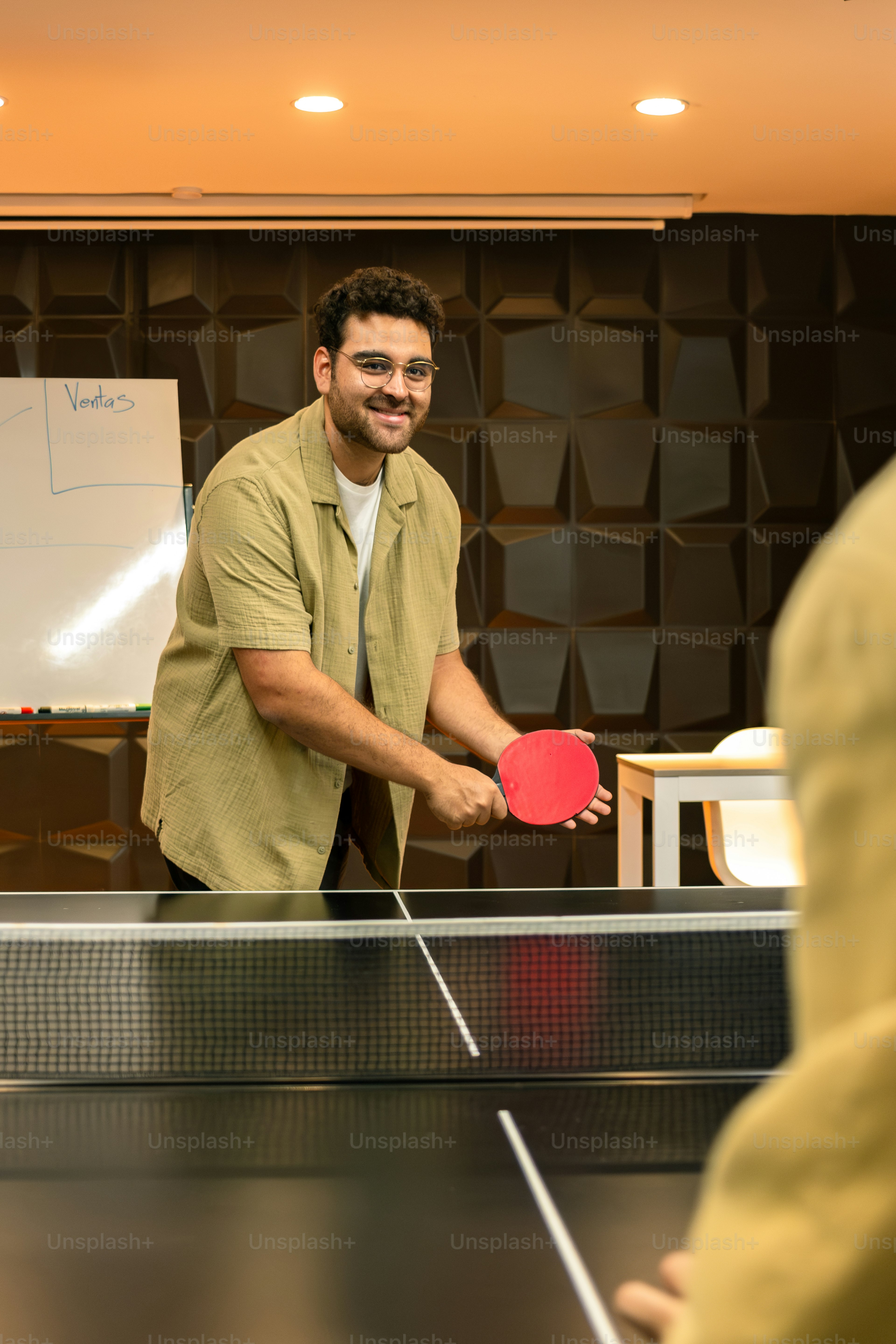 Man smiling while playing ping pong.