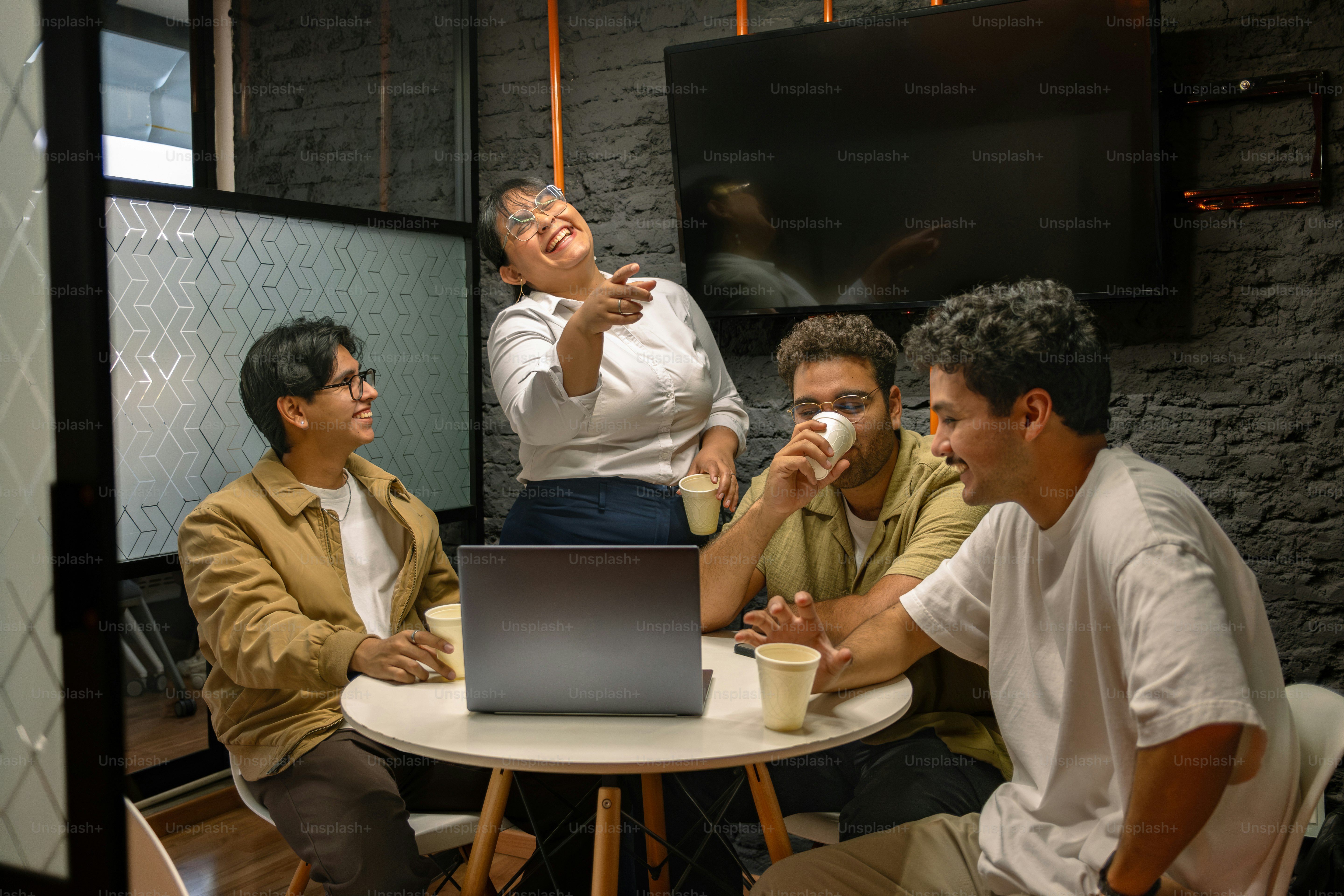 People are having a meeting with coffee and laptops.