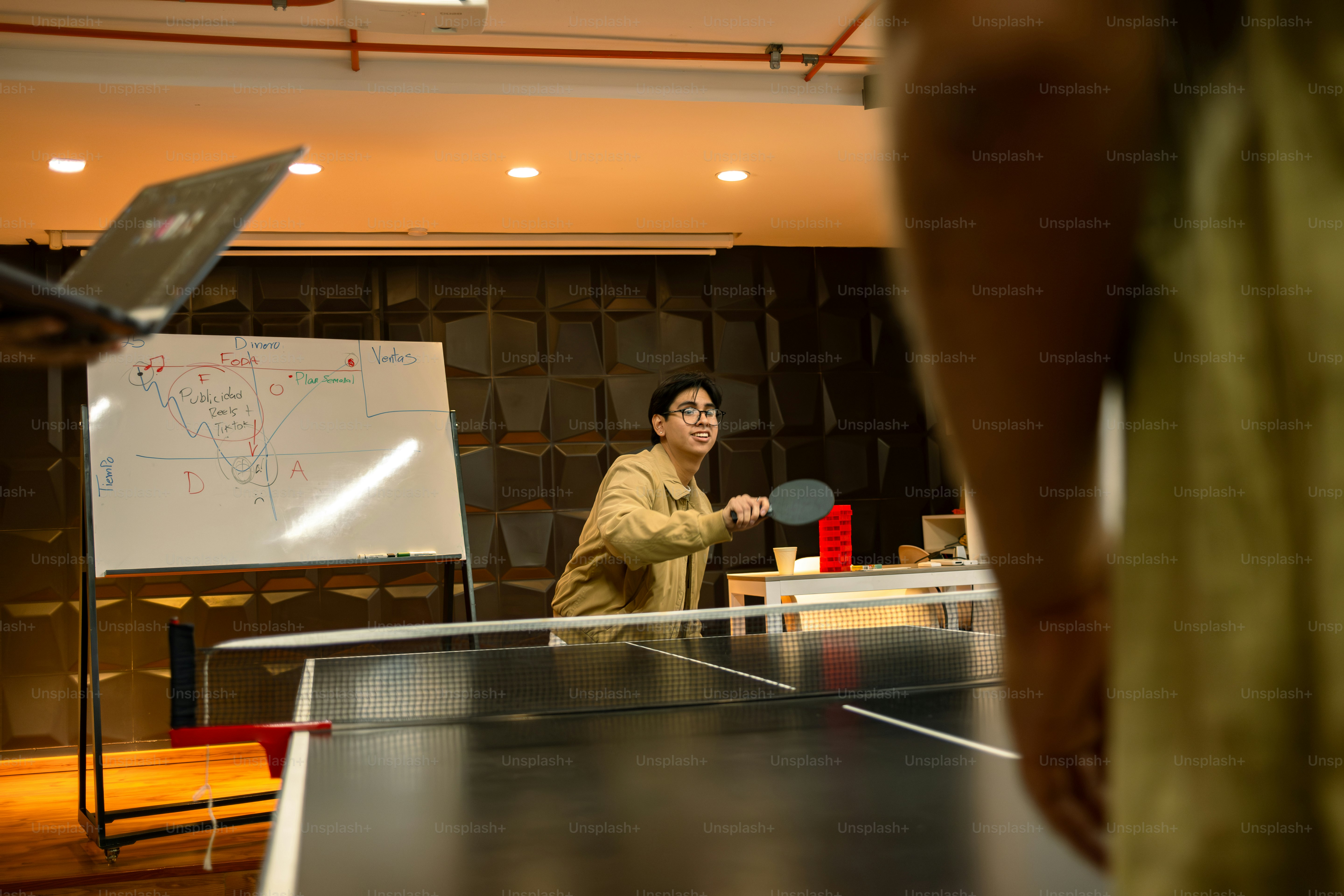 People are playing ping pong in an office space.