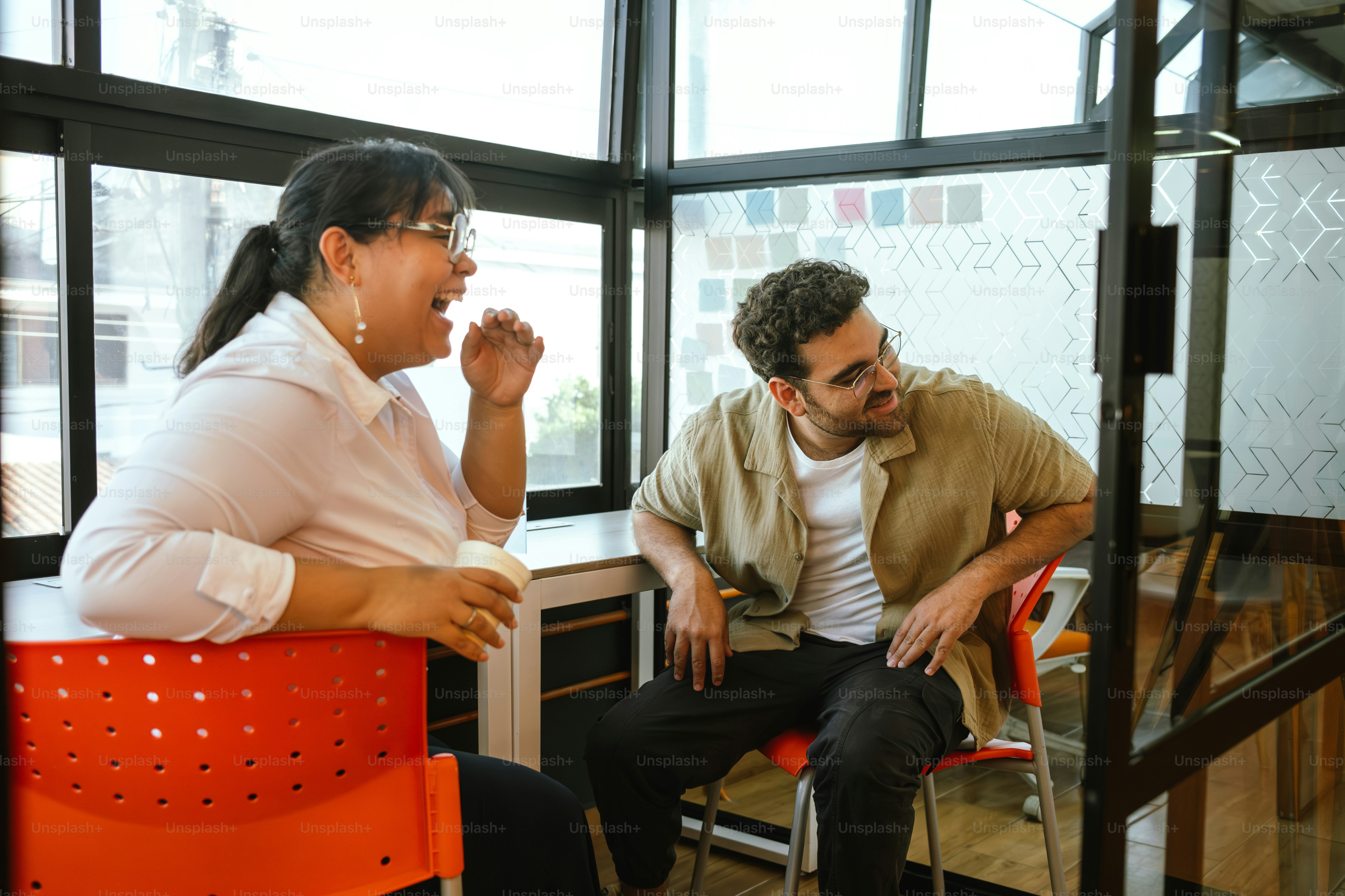 Two people share a laugh while sitting together.