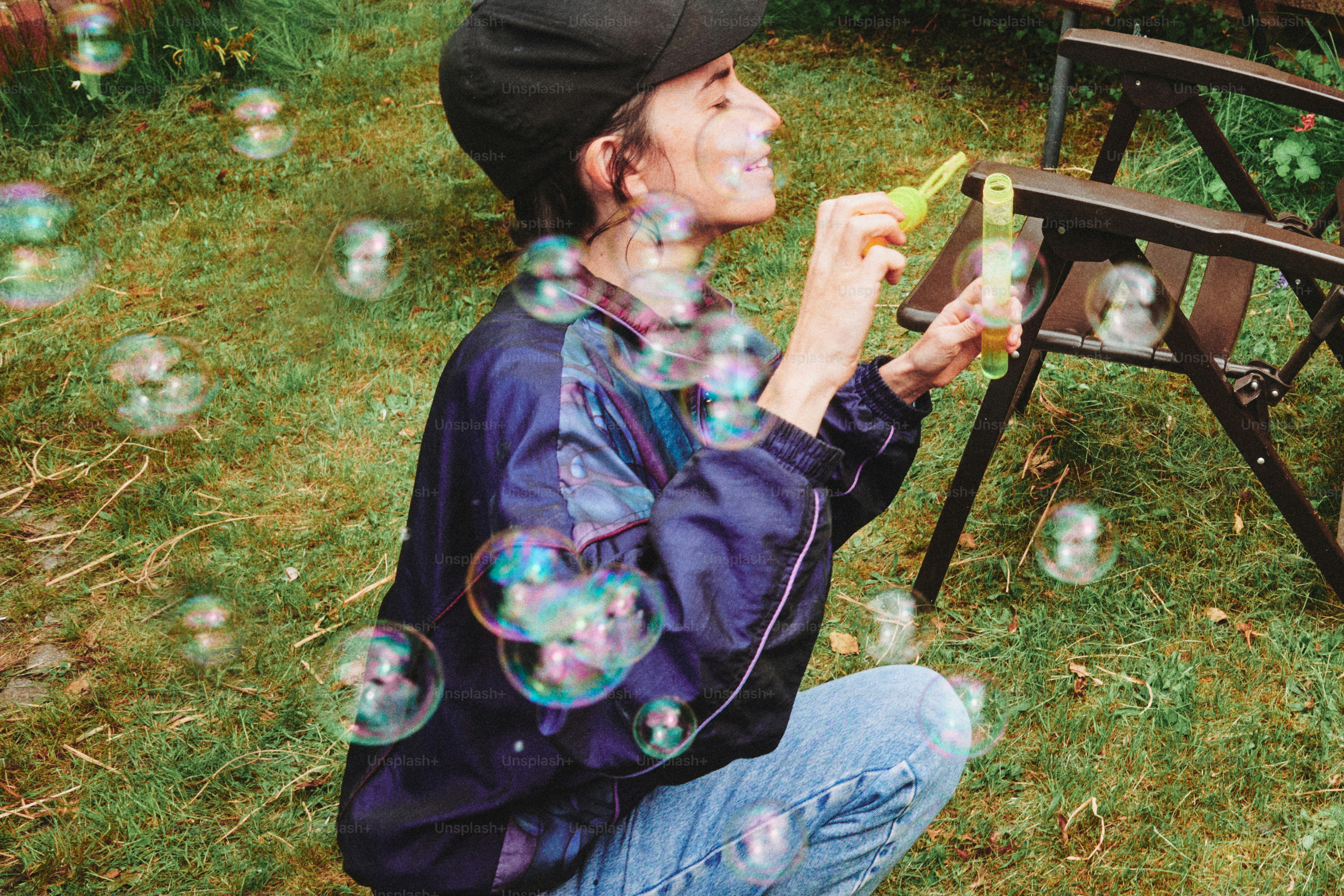 La donna soffia bolle in un'area erbosa.