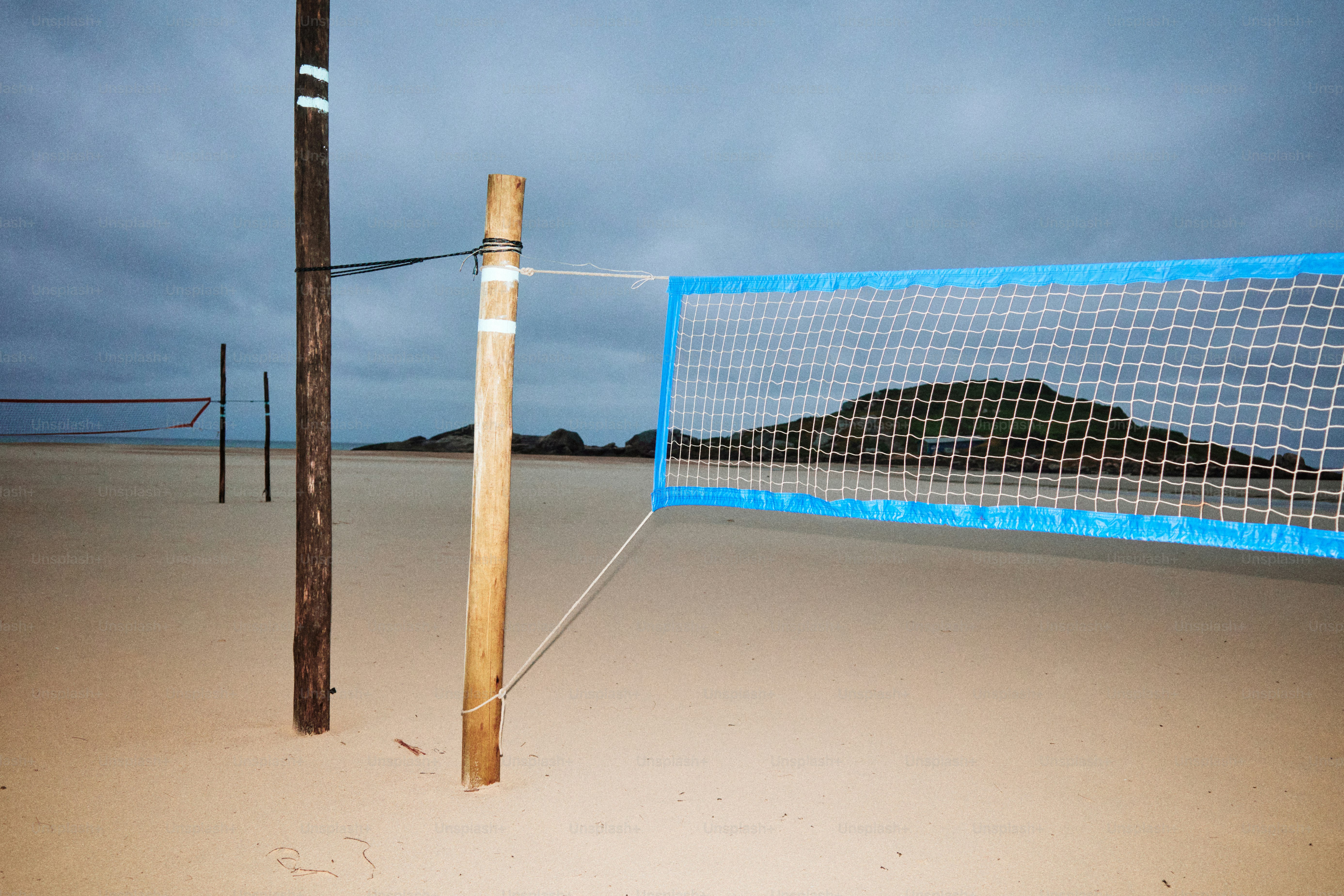 Le filet de volley-ball est prêt sur une plage de sable.