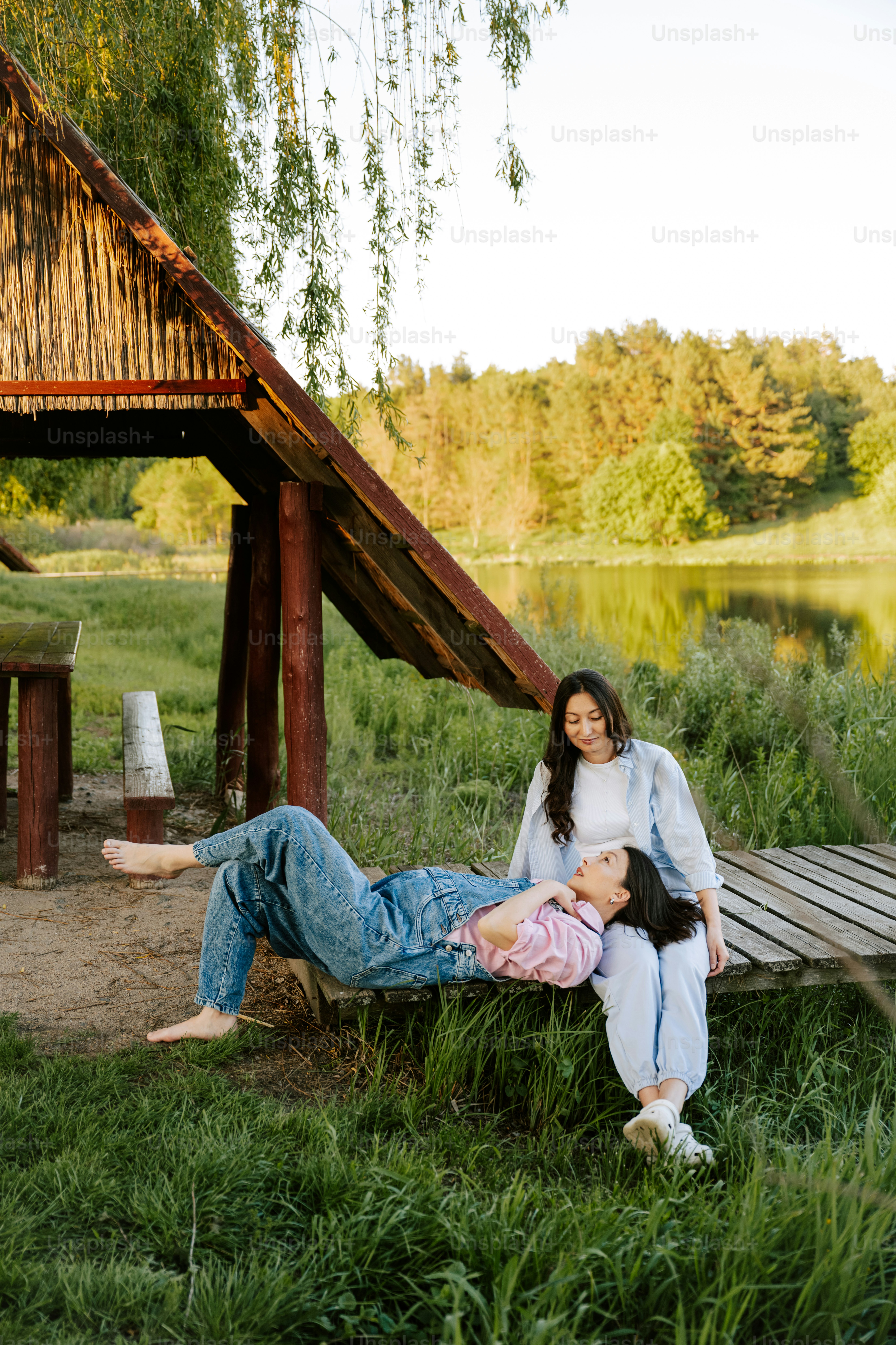 Two women relax together in a peaceful outdoor setting.