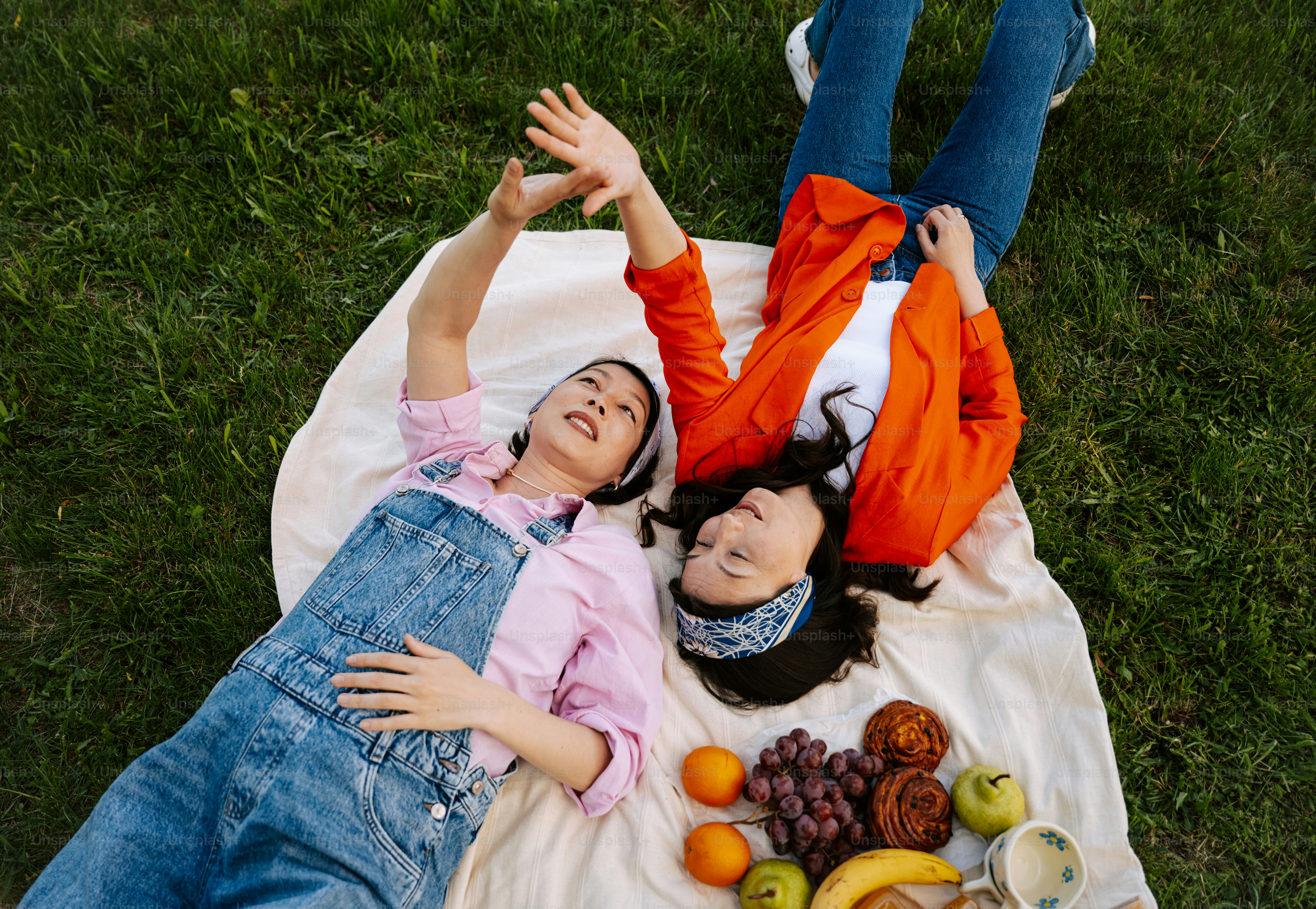 Two friends relax and enjoy a picnic outdoors.