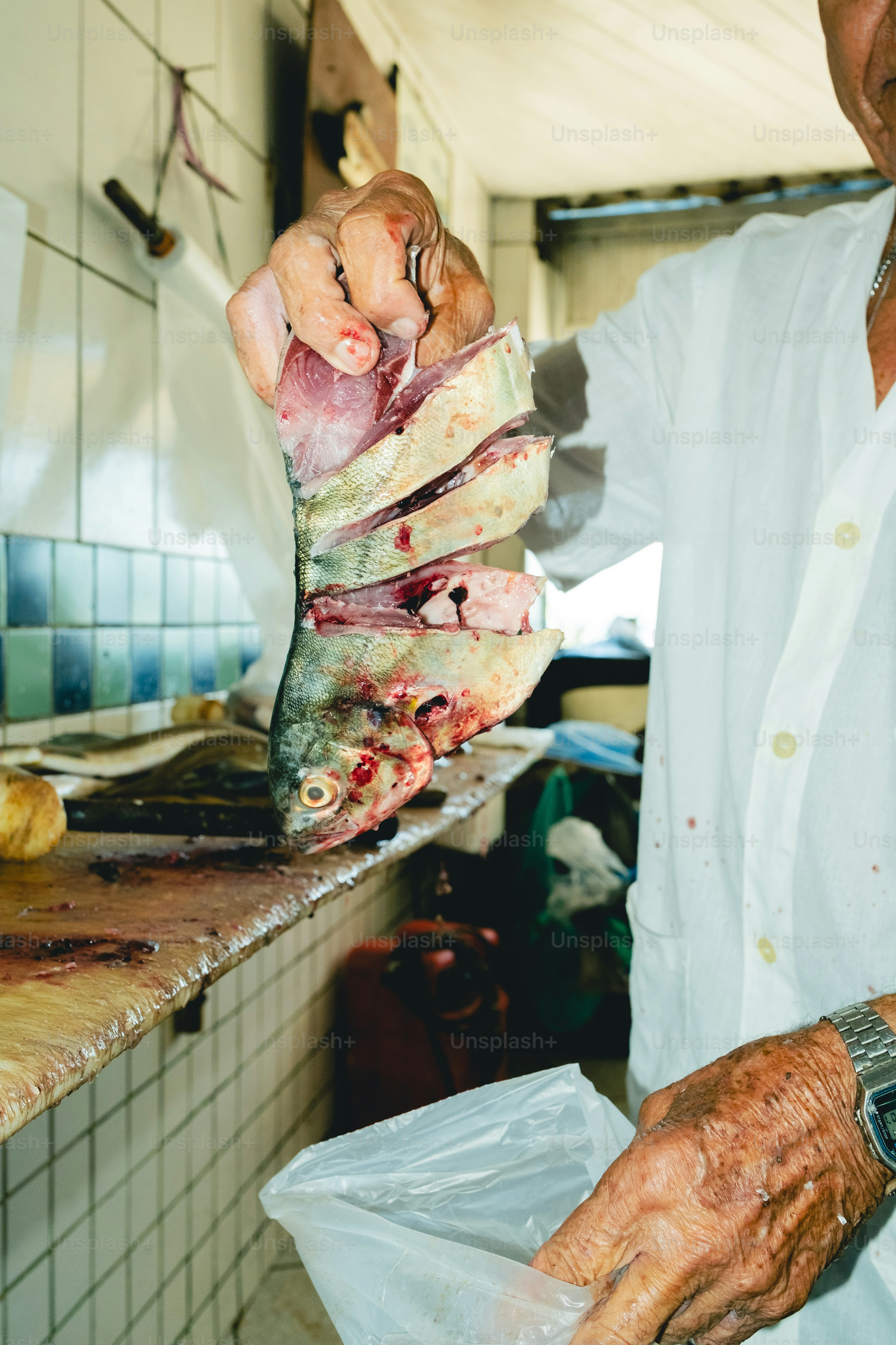 A man holds sliced fish, ready for sale.