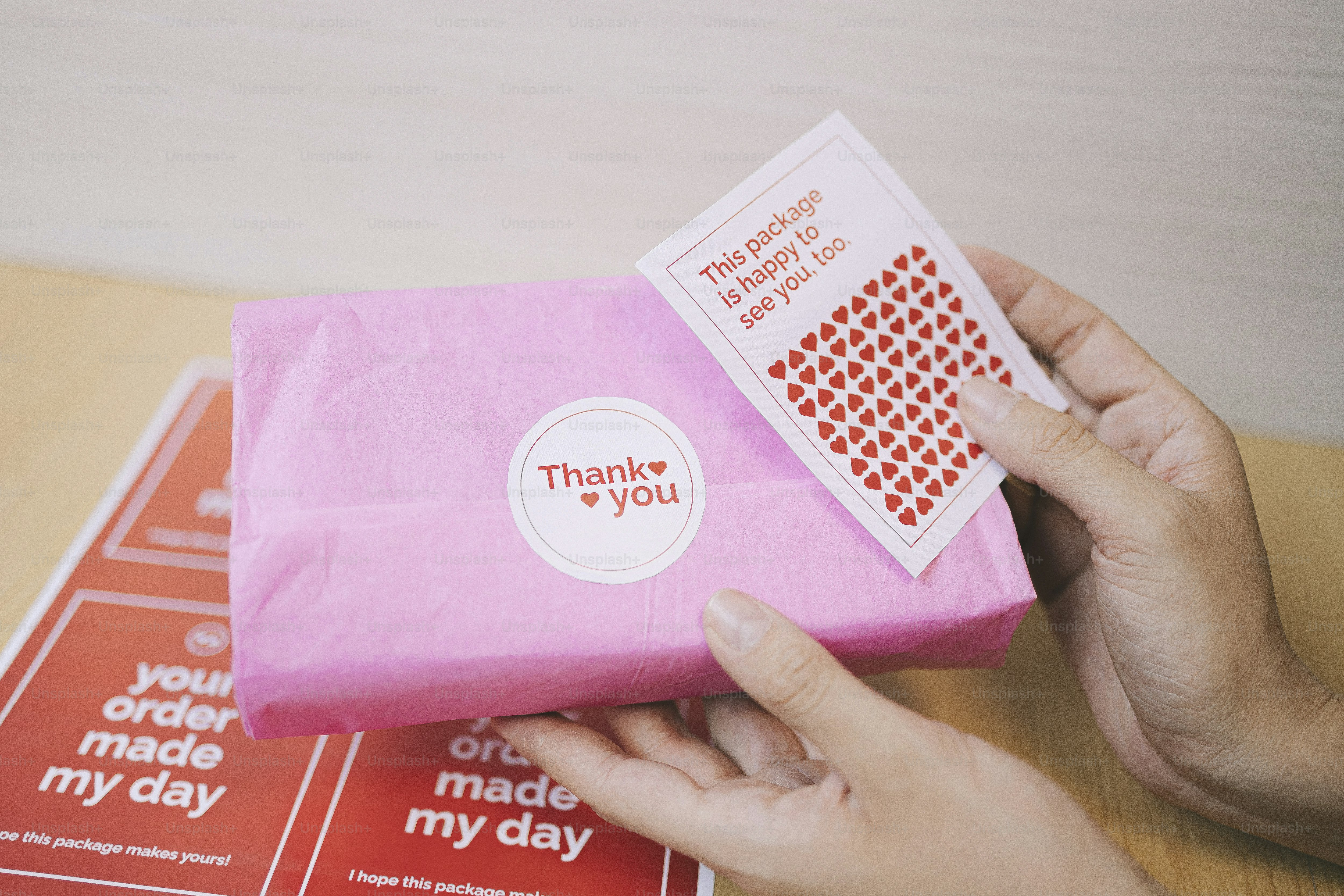Kotak hadiah merah muda dengan kartu ucapan terima kasih.