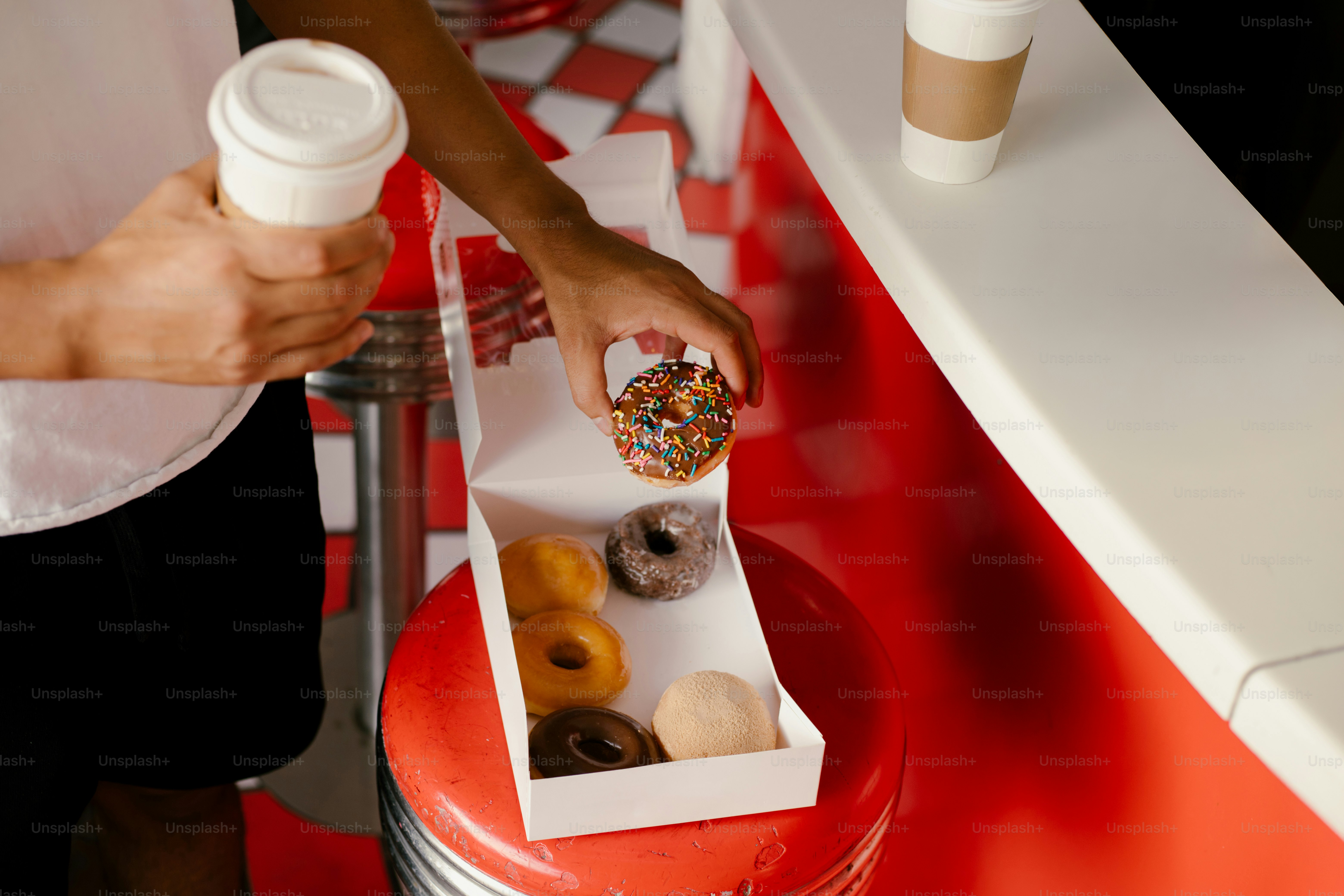 Someone is choosing a donut from a box.