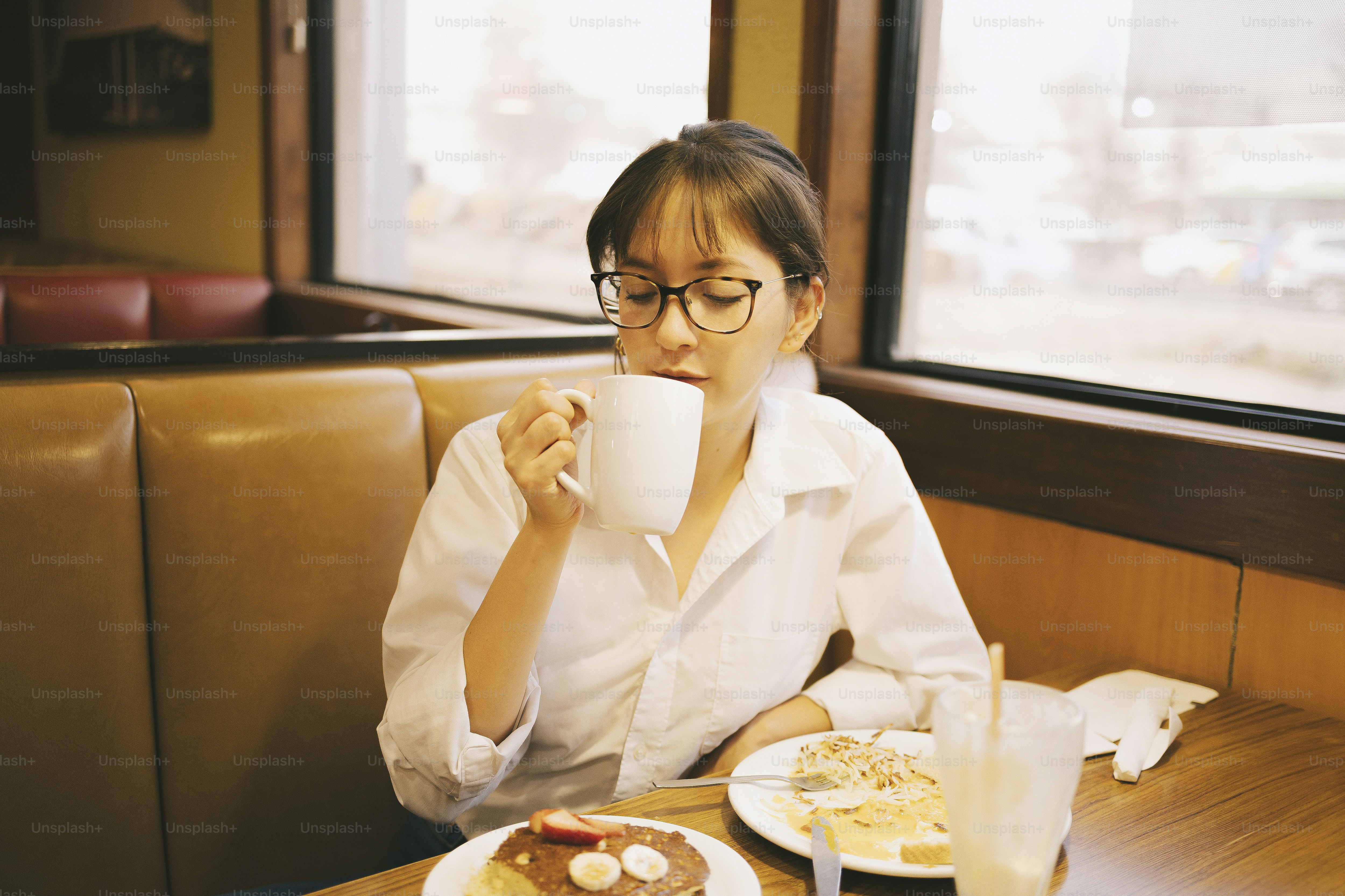 Woman enjoys a drink with her breakfast.
