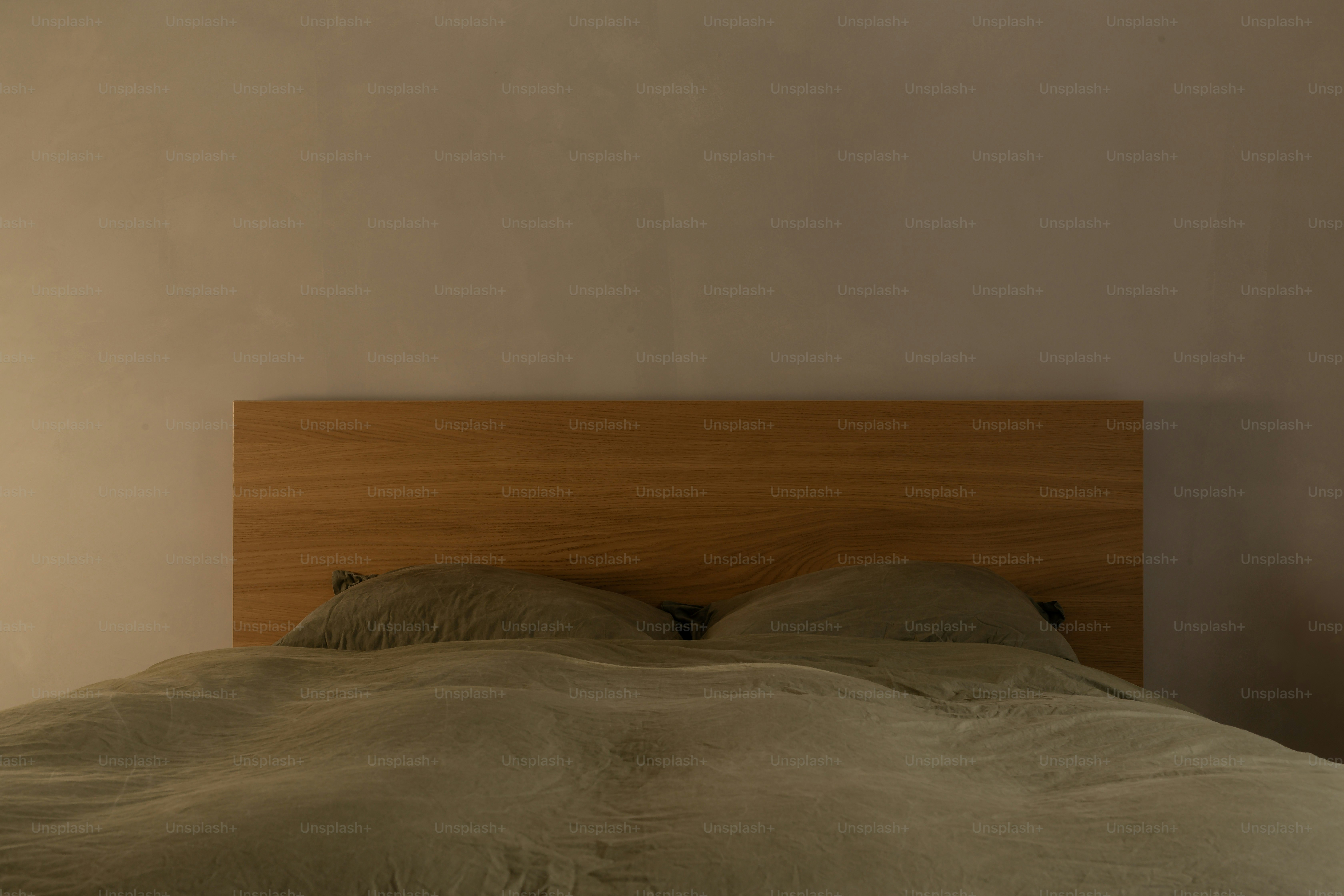 A bed is made with pillows and a wooden headboard.