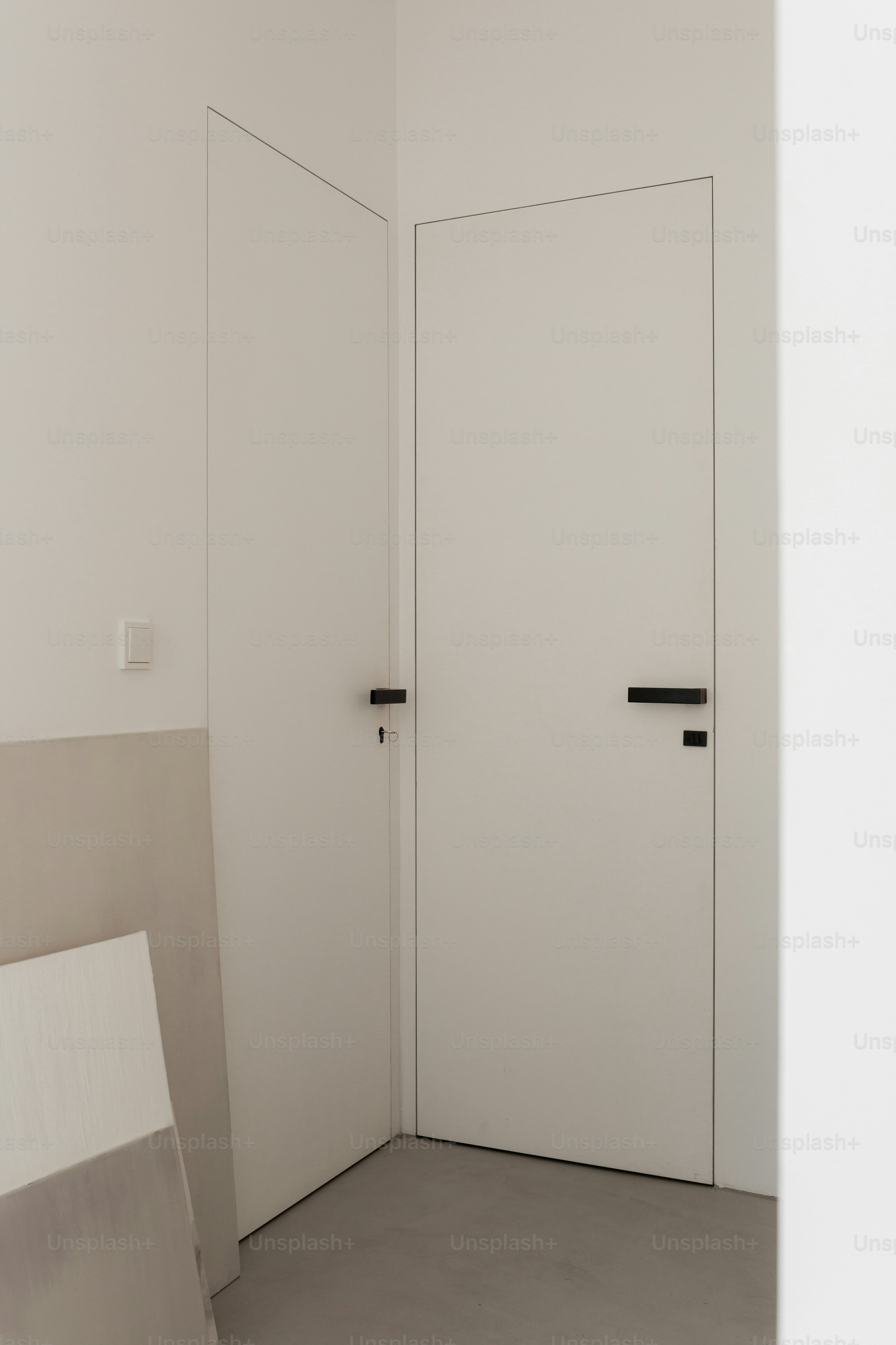 Two white doors in a minimalist interior.