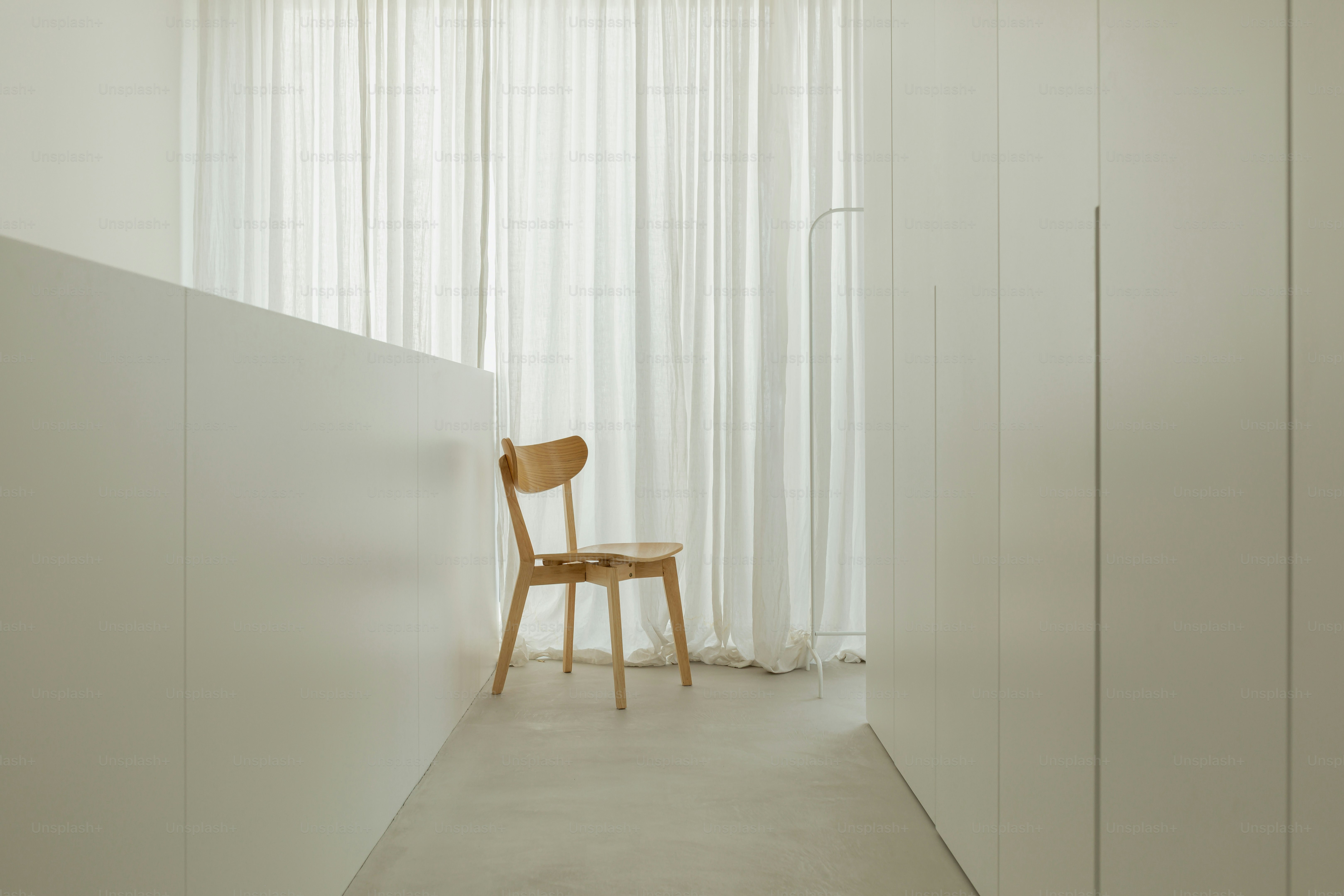 Una silla de madera se encuentra en un pasillo muy iluminado.