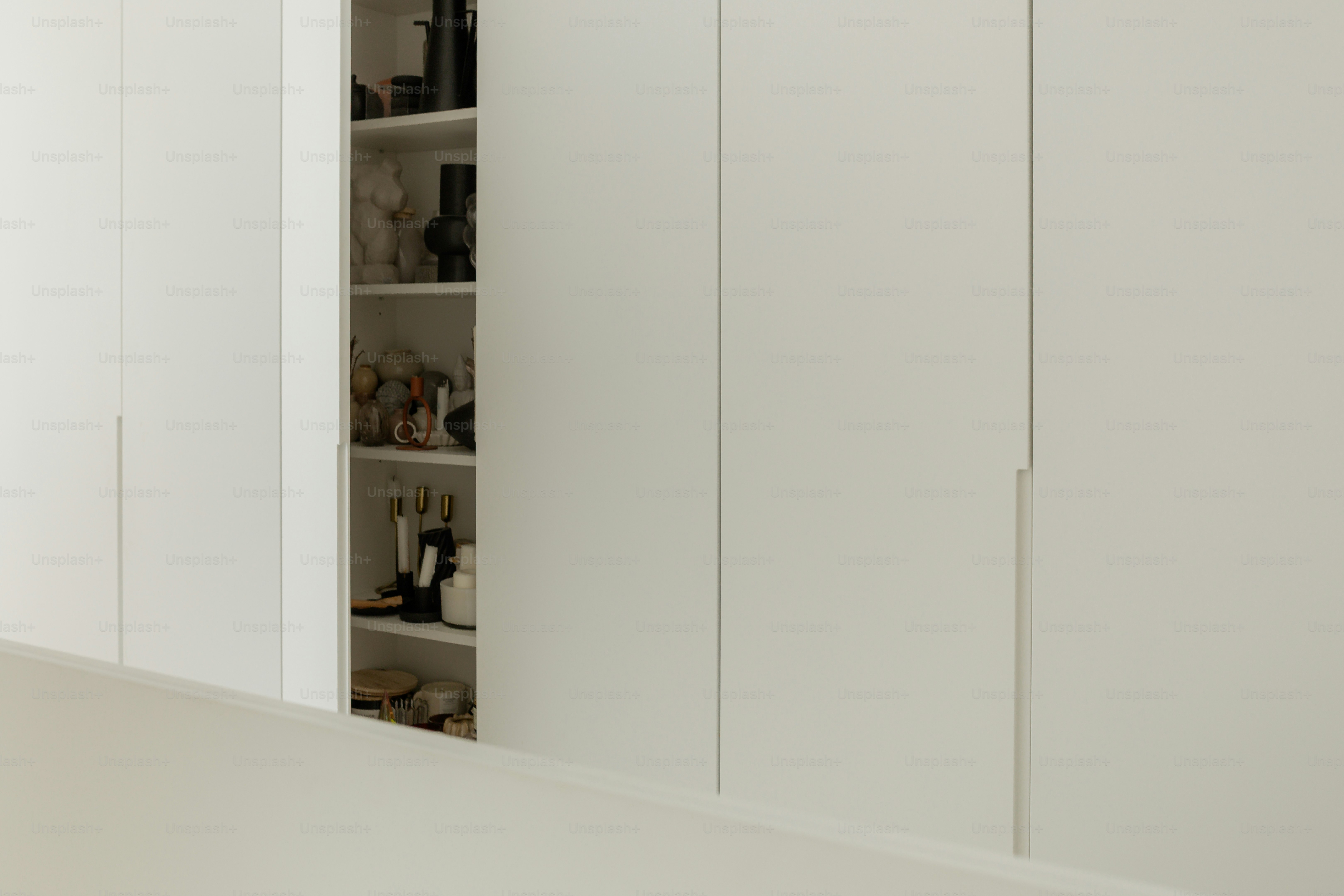 Ein weißer Einbauschrank mit verstauten Gegenständen.