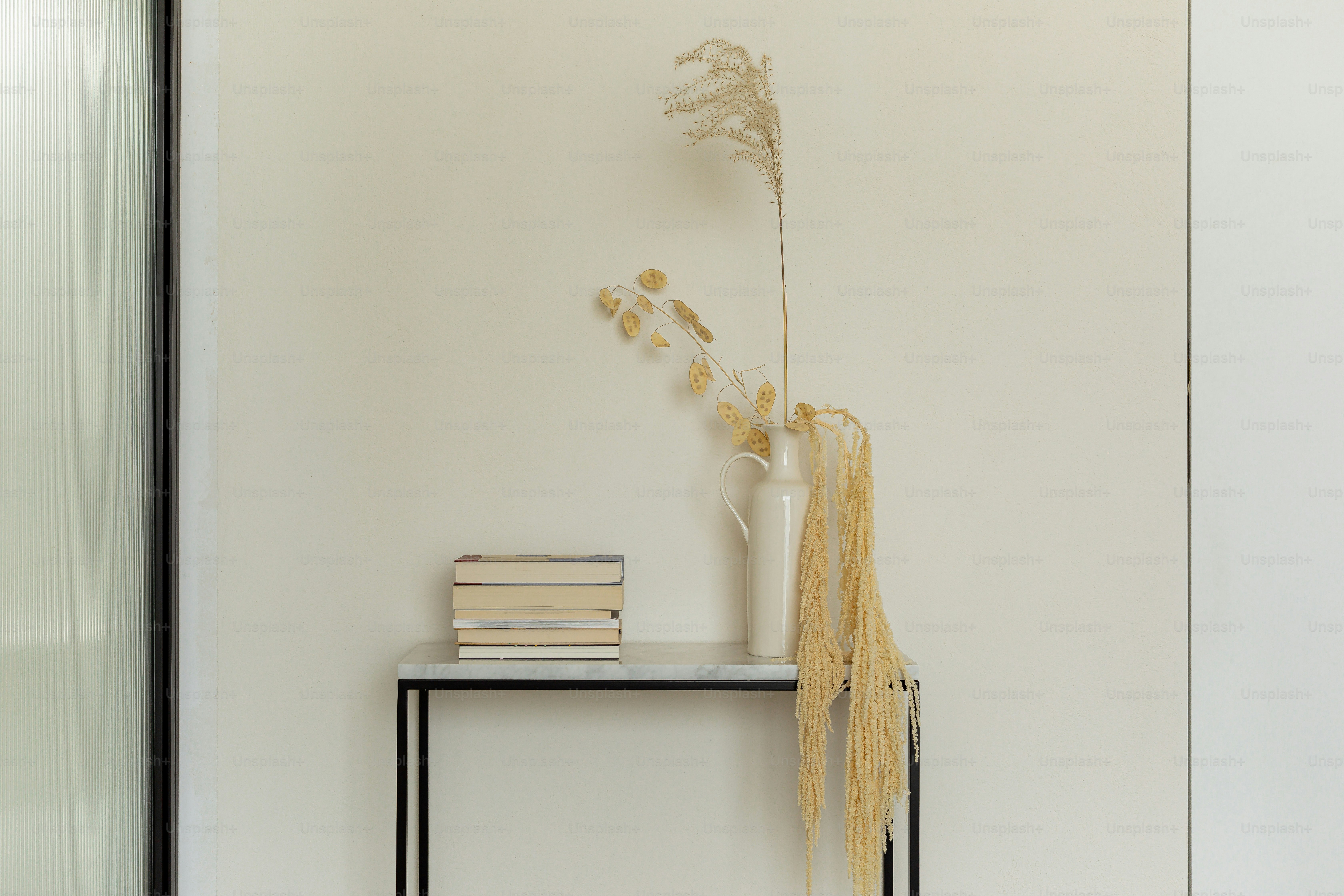 Dried flowers and books decorate a console table.