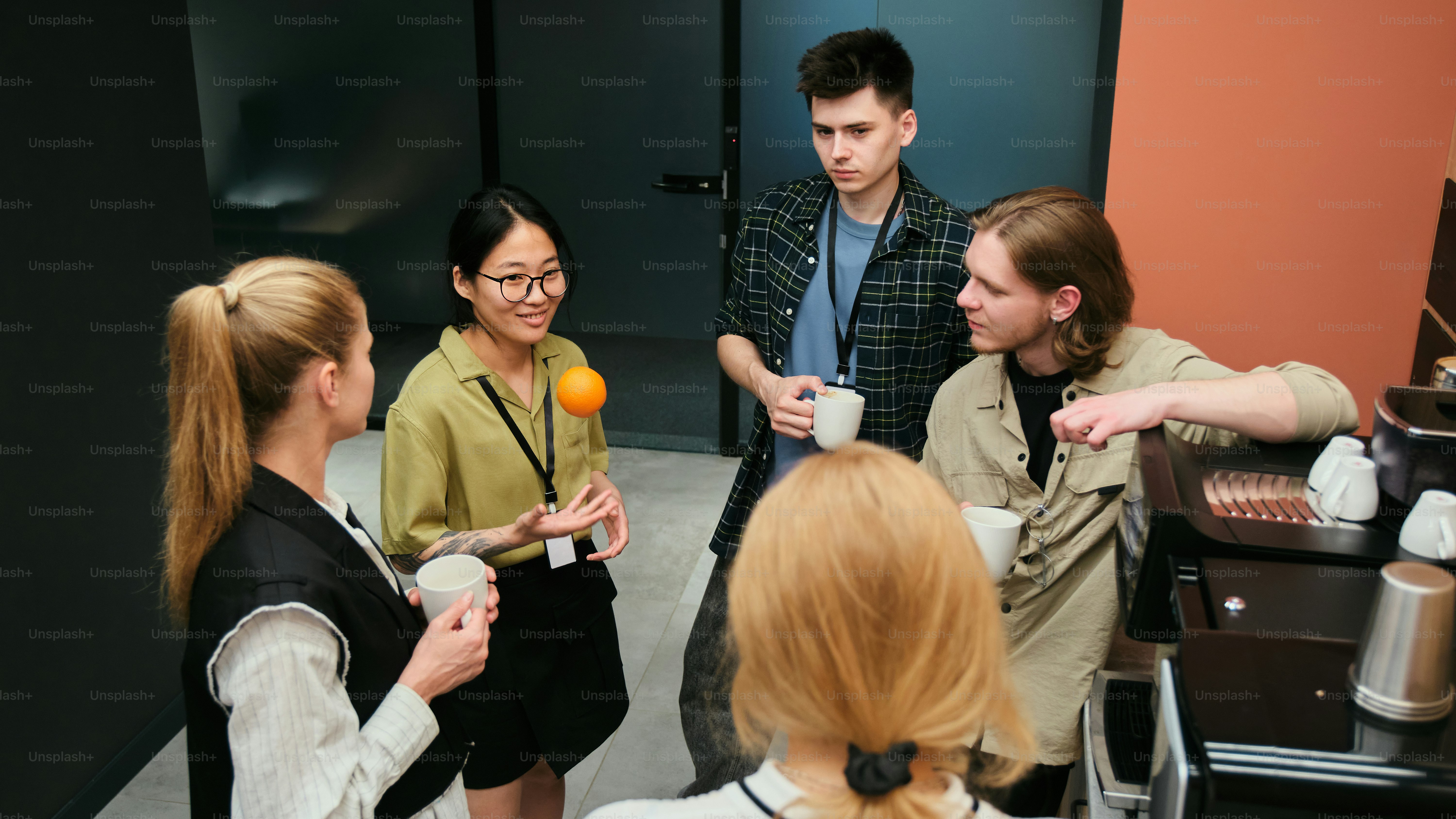 Les collègues profitent d’une pause, discutent et tiennent des tasses de café.