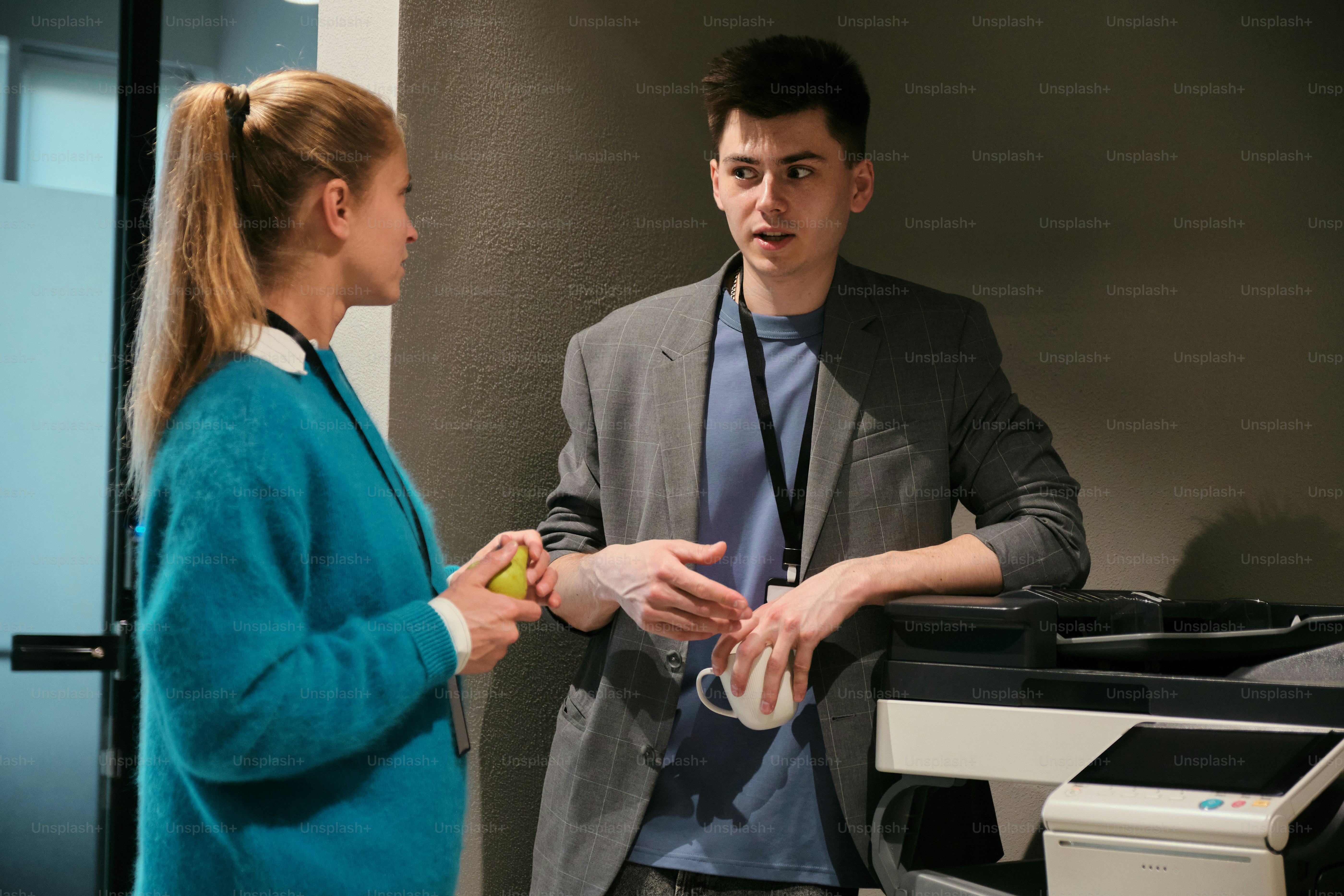 Zwei Kollegen unterhalten sich in einer Büroumgebung.