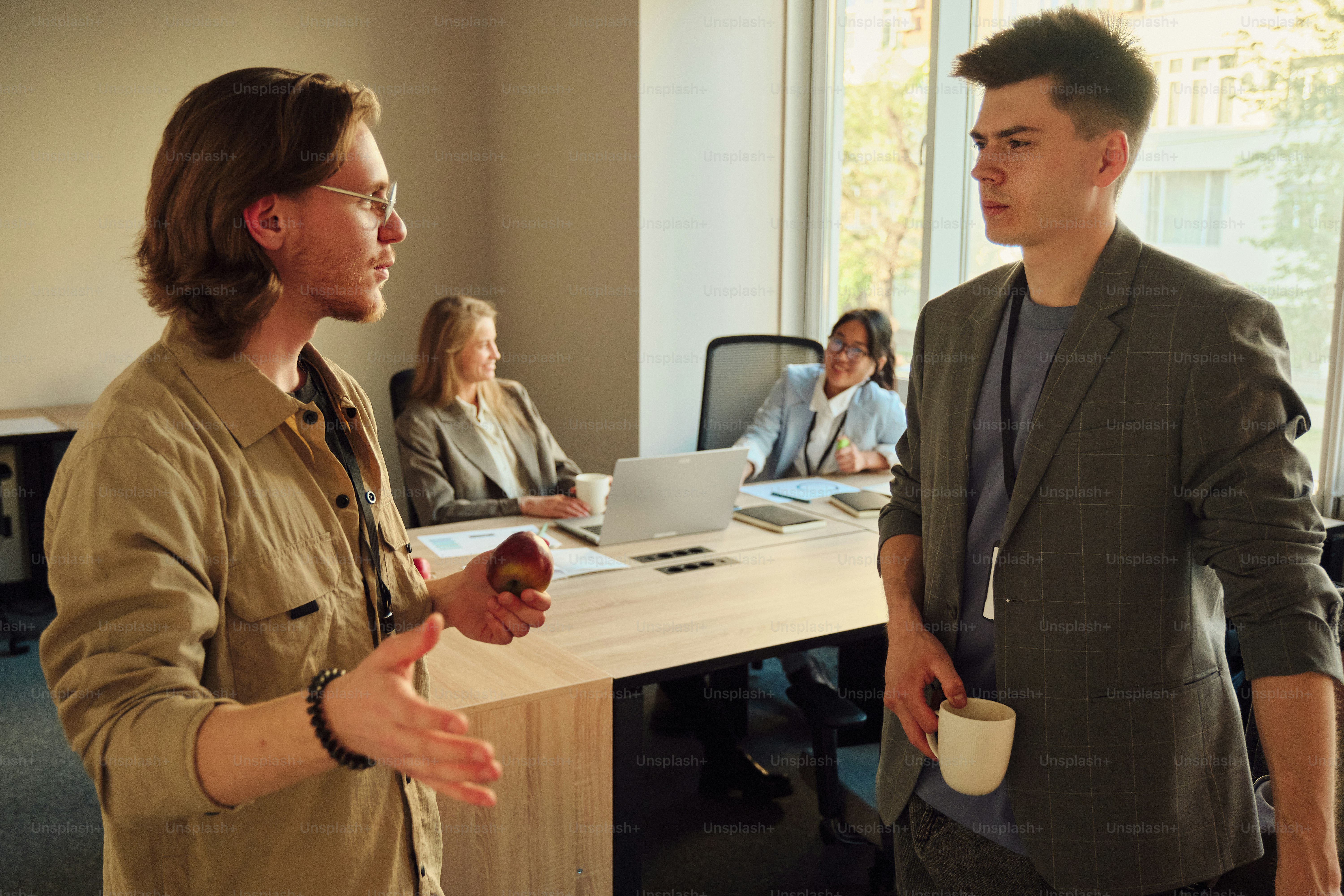 Two men converse in an office