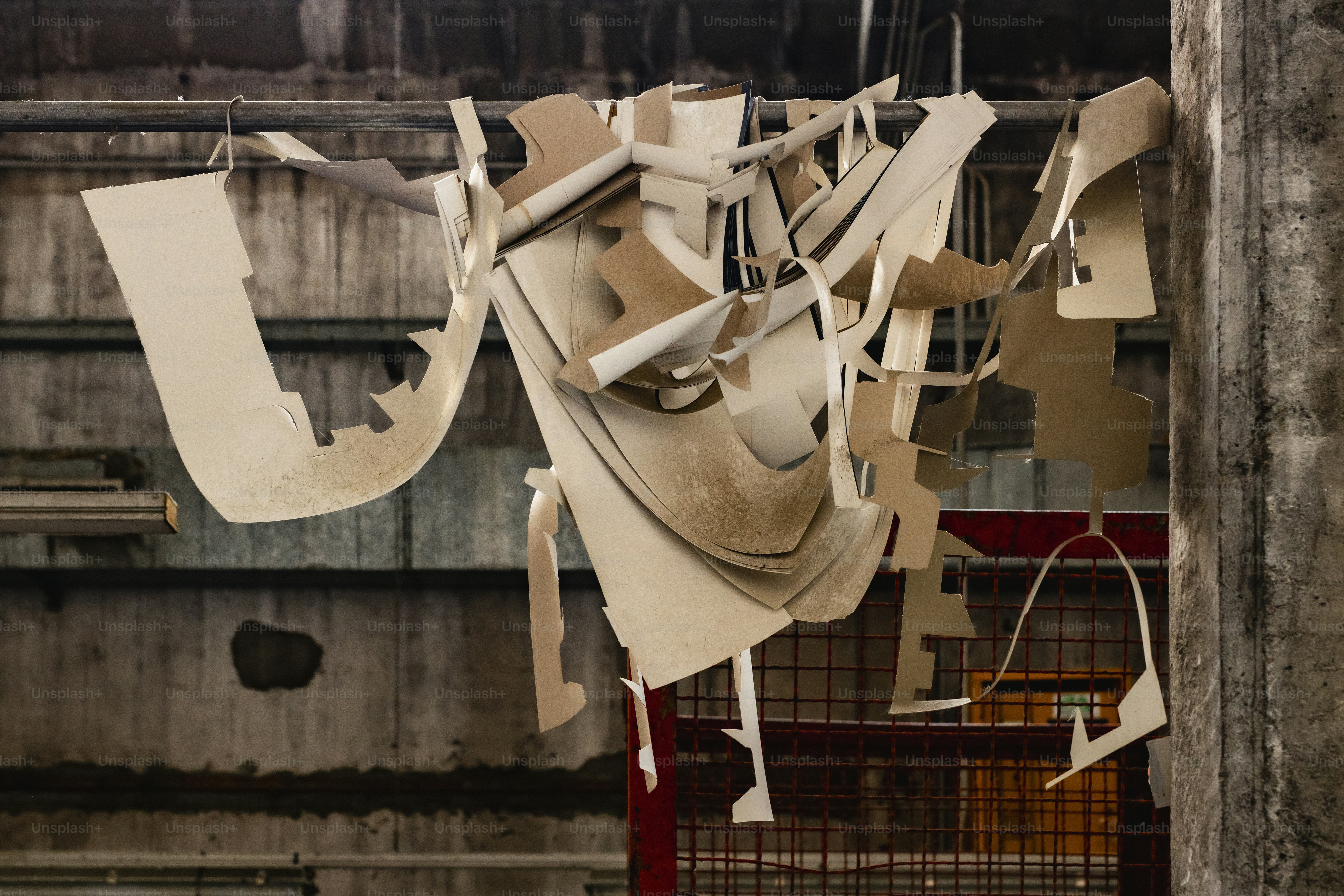 Cardboard scraps hang in an industrial setting.