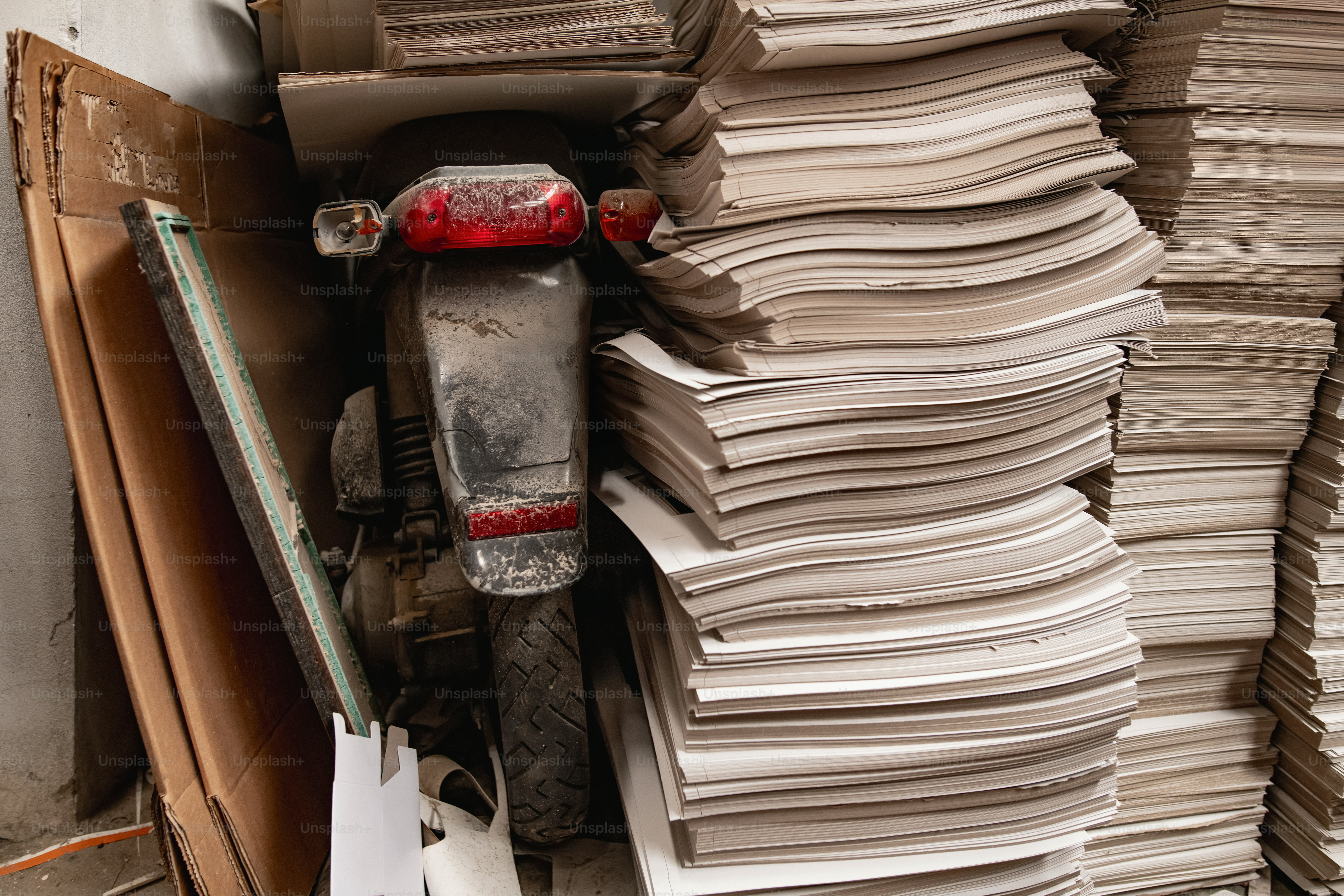 A scooter sits next to a stack of papers.