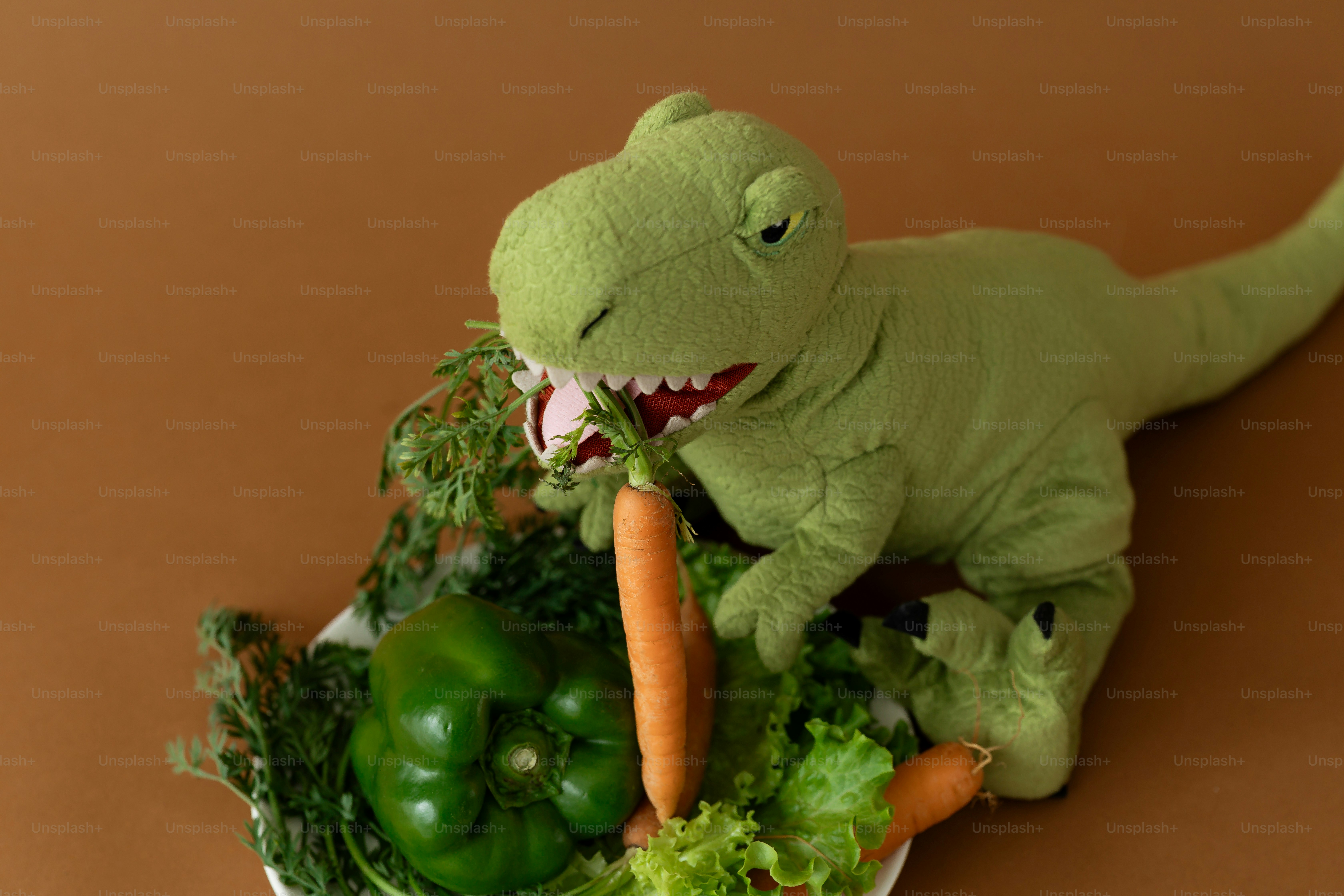 A dinosaur enjoys healthy vegetables from a plate.