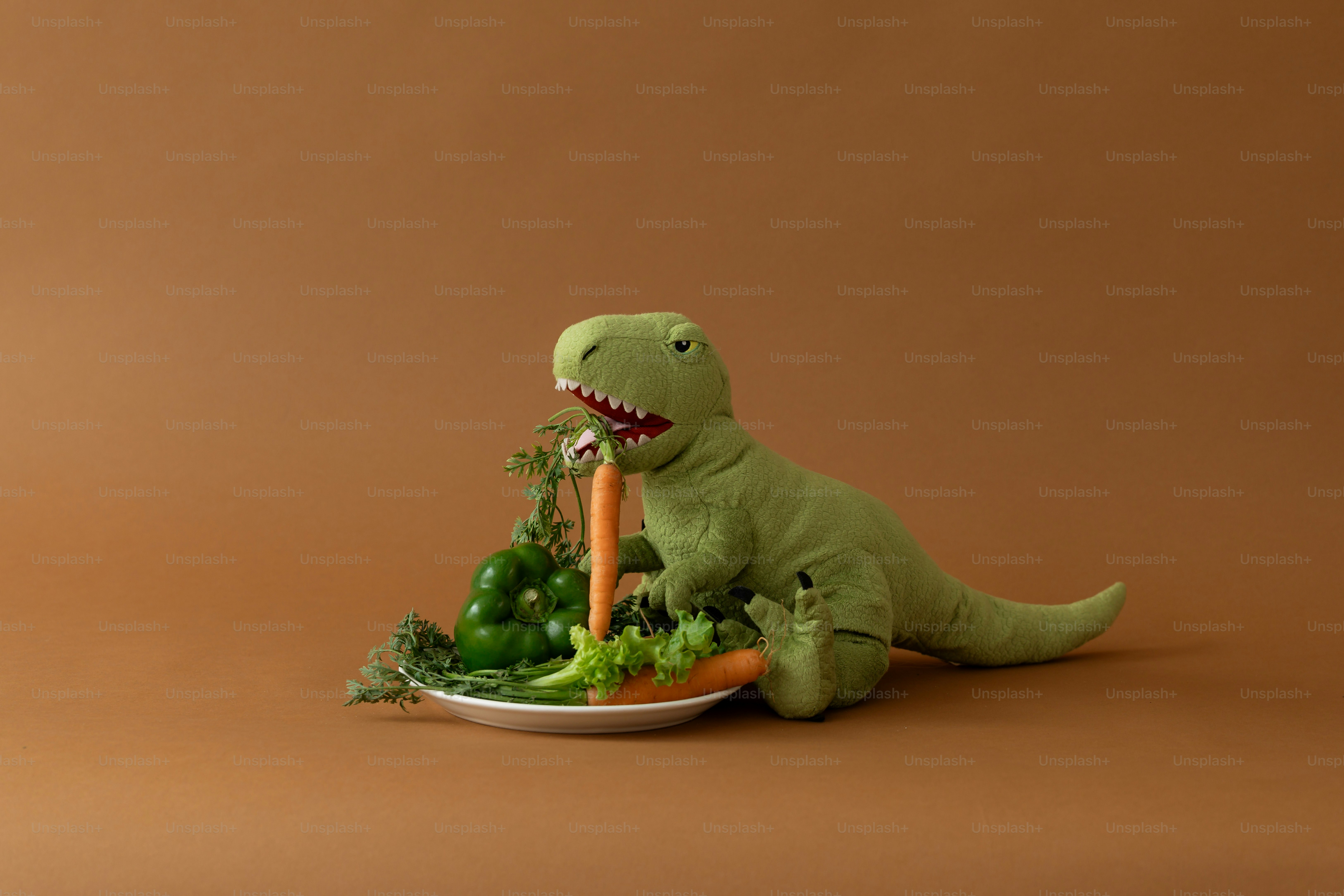 A stuffed dinosaur eats fresh vegetables.