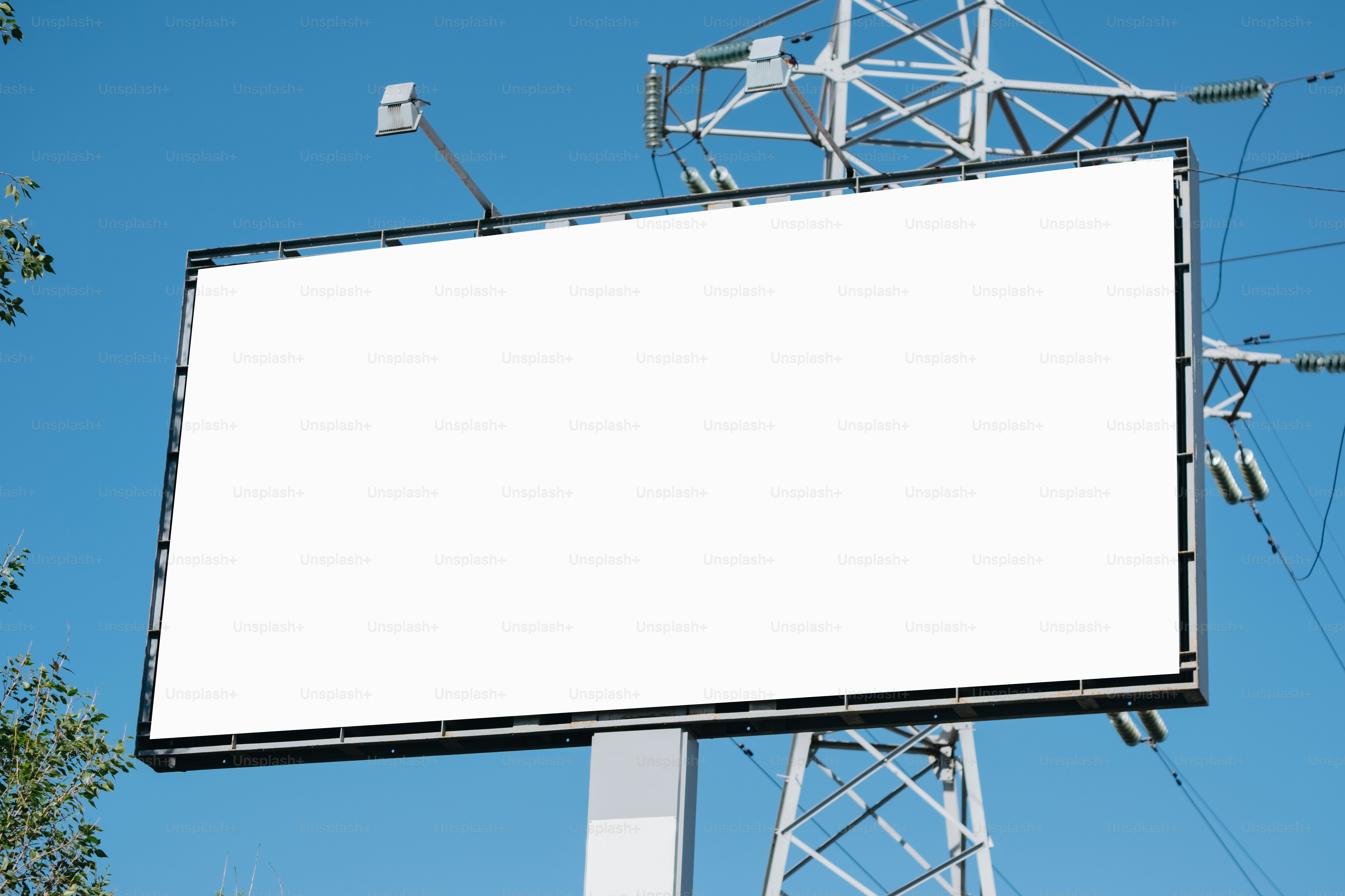 A blank billboard stands against a blue sky.