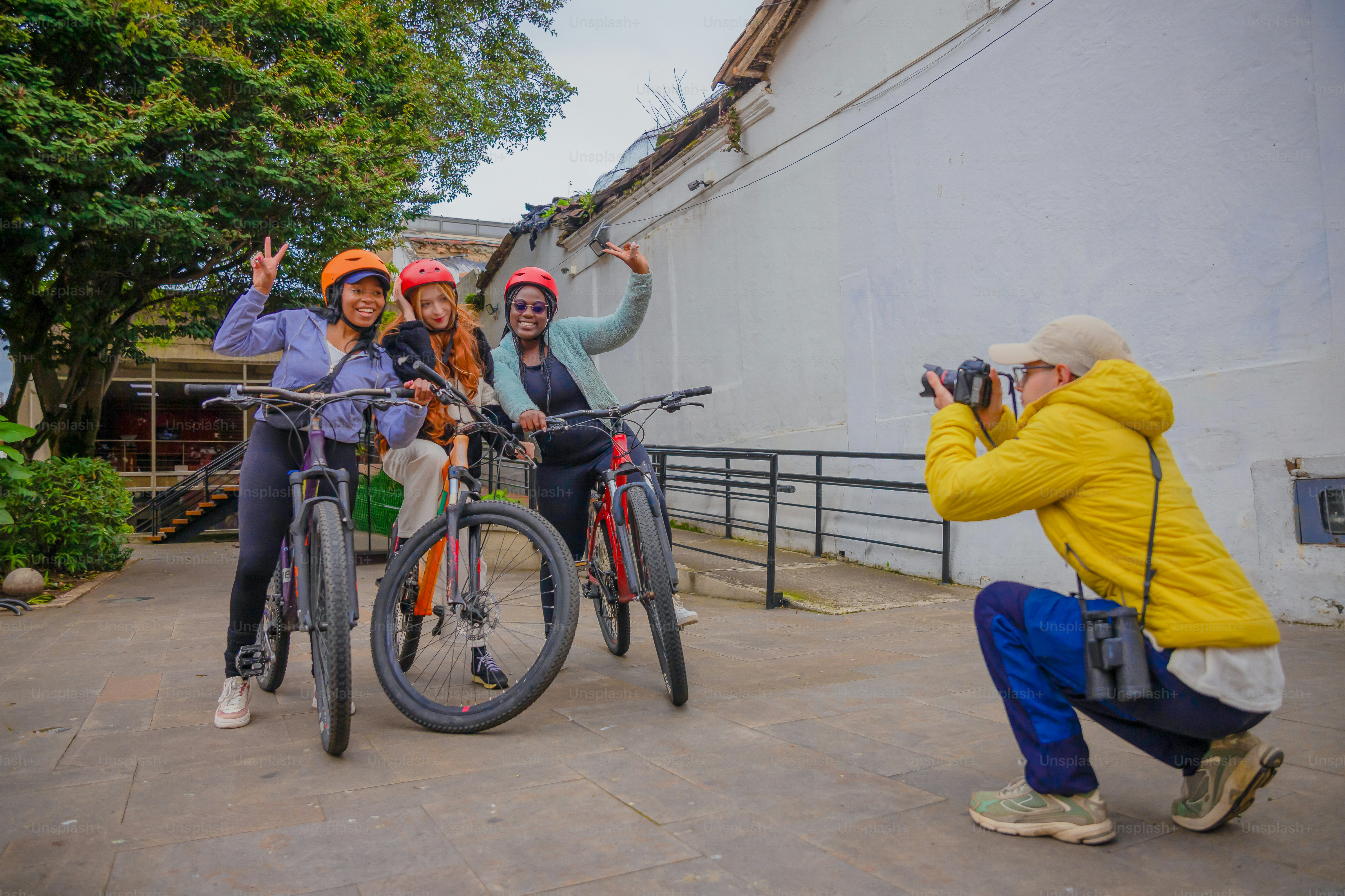 Friends pose with their bikes while being photographed.