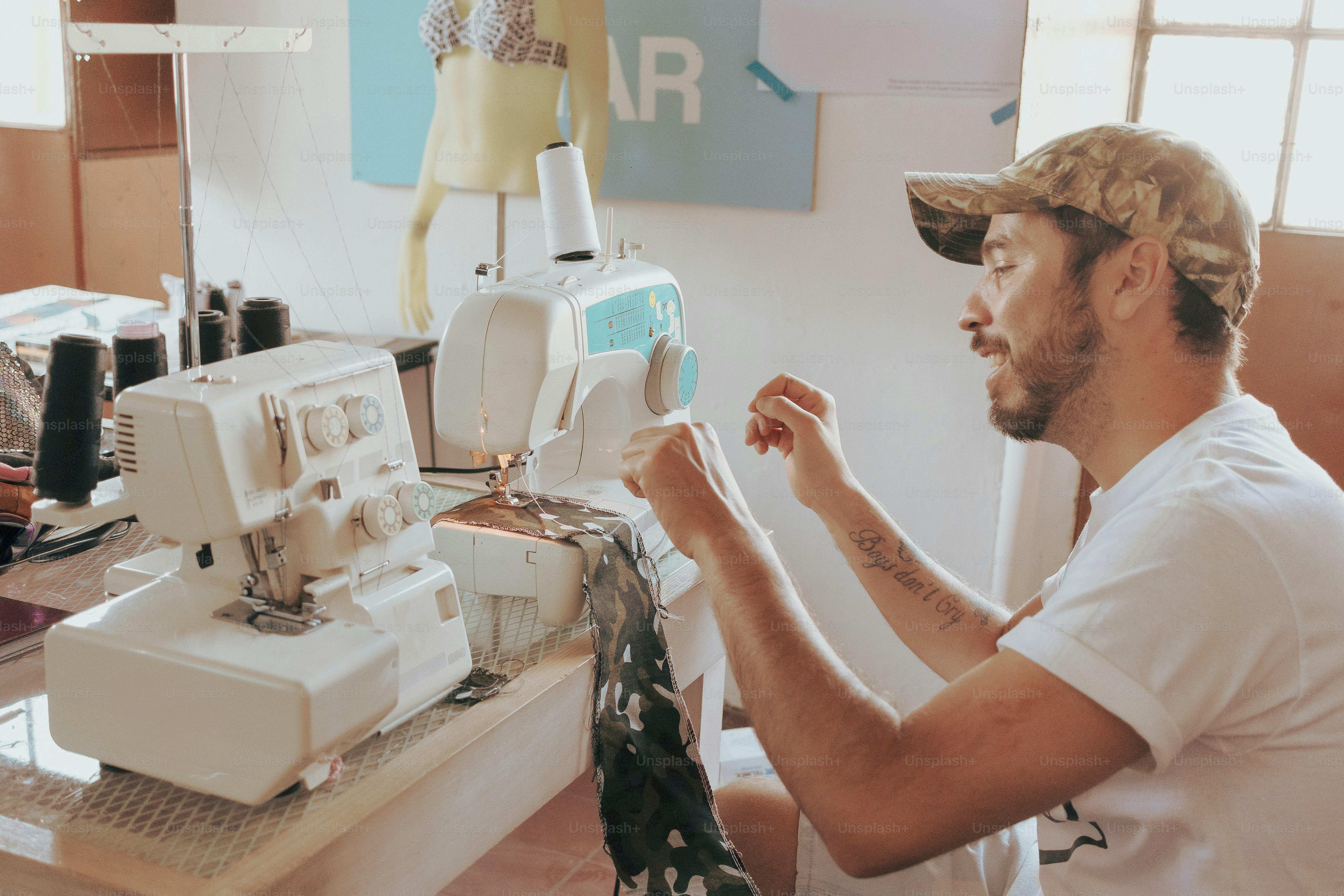A man uses a sewing machine. photo – Workshop Image on Unsplash