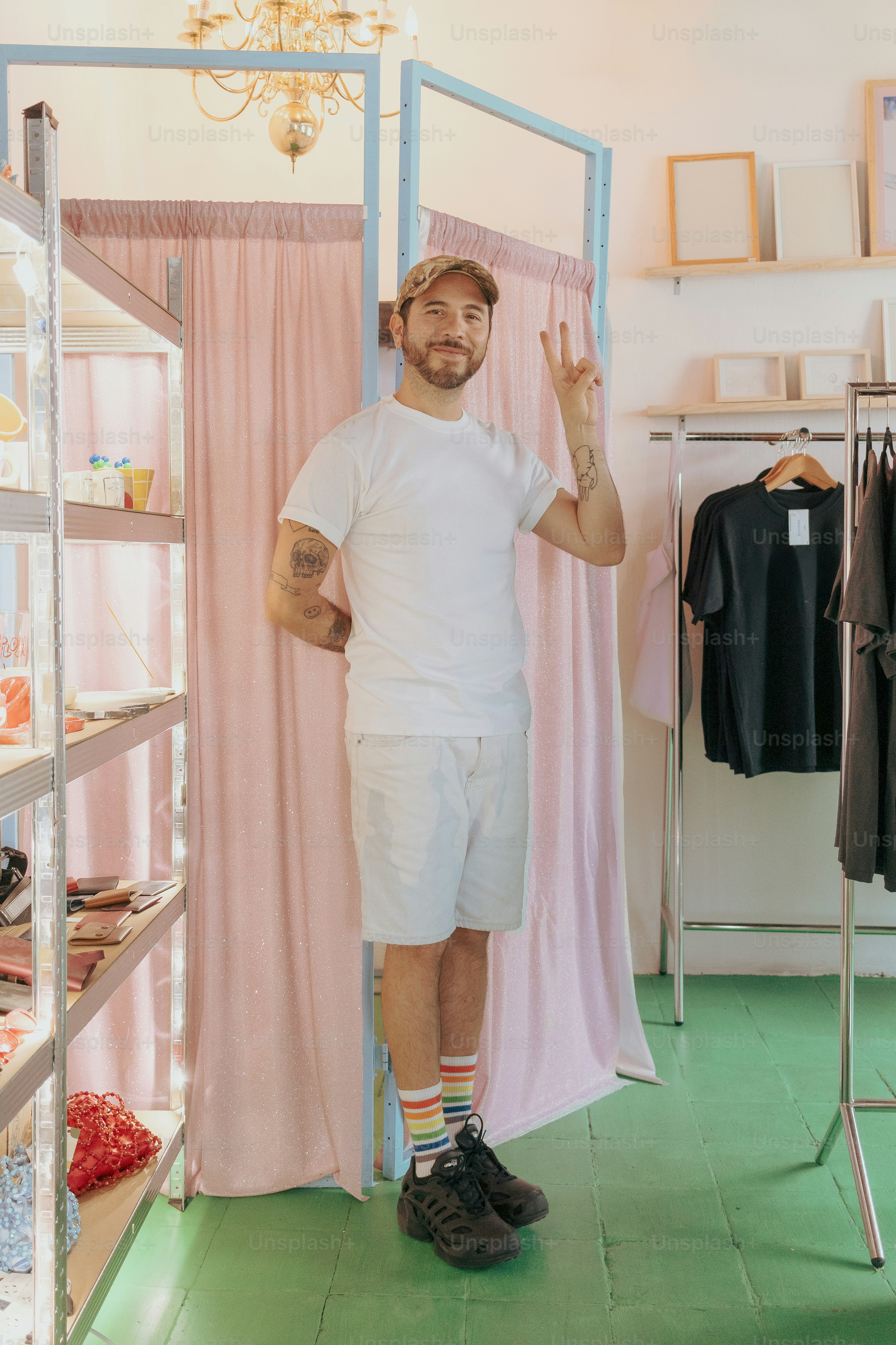 Man in shop, showing three fingers and smiling